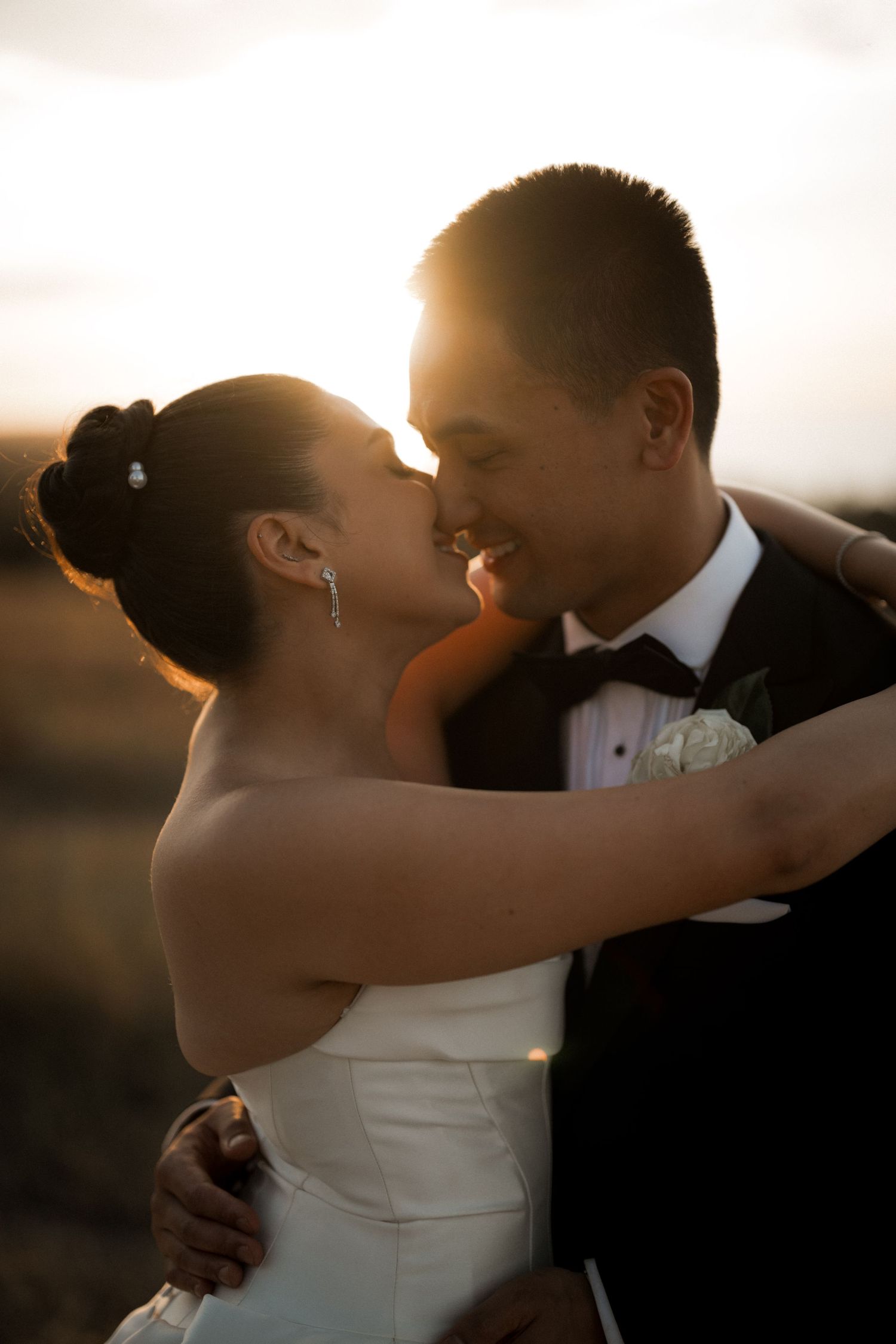Romantic sunset silhouette of couple embracing in golden hour light.