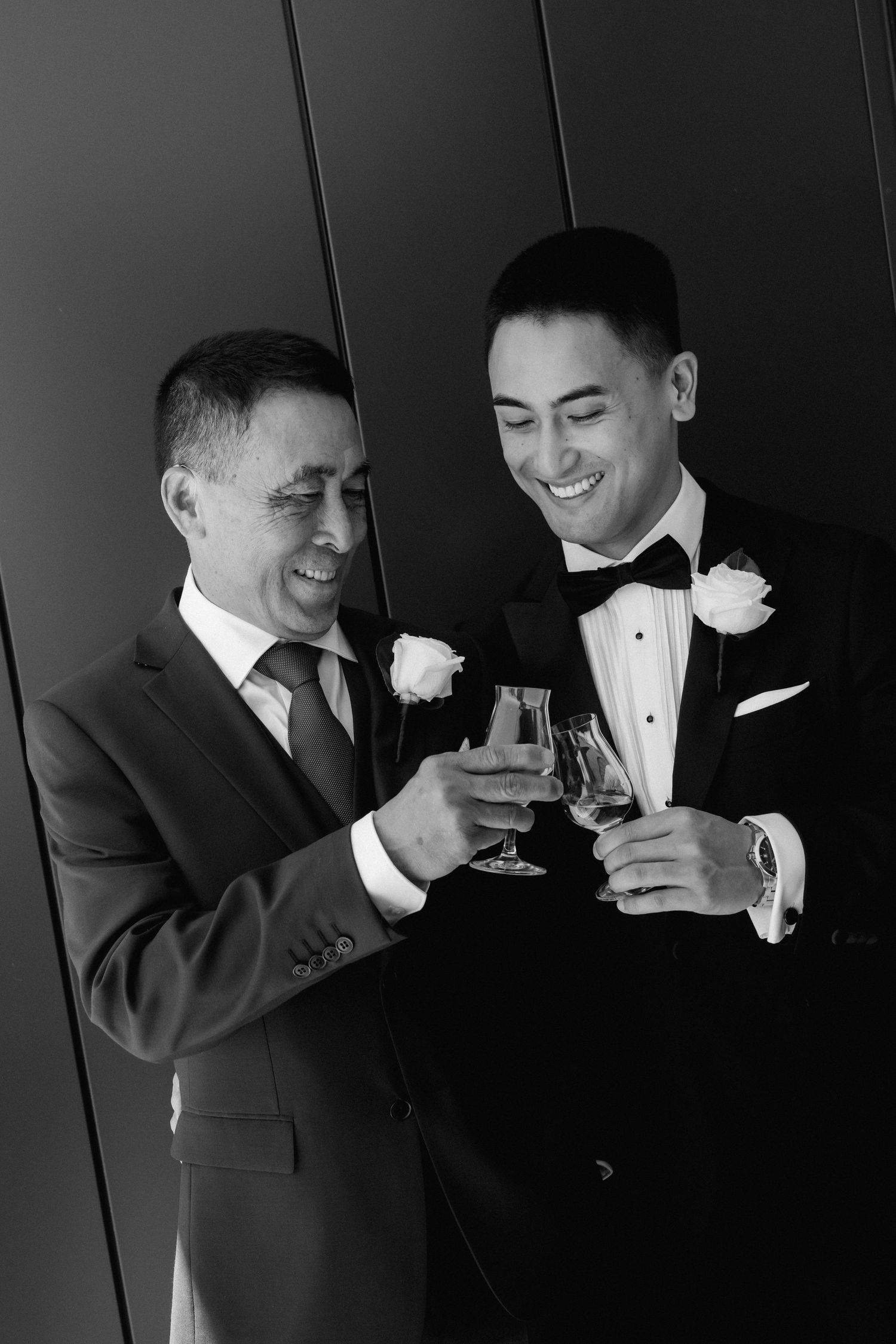 Two people in formal attire share a celebratory toast with champagne glasses at an elegant event.