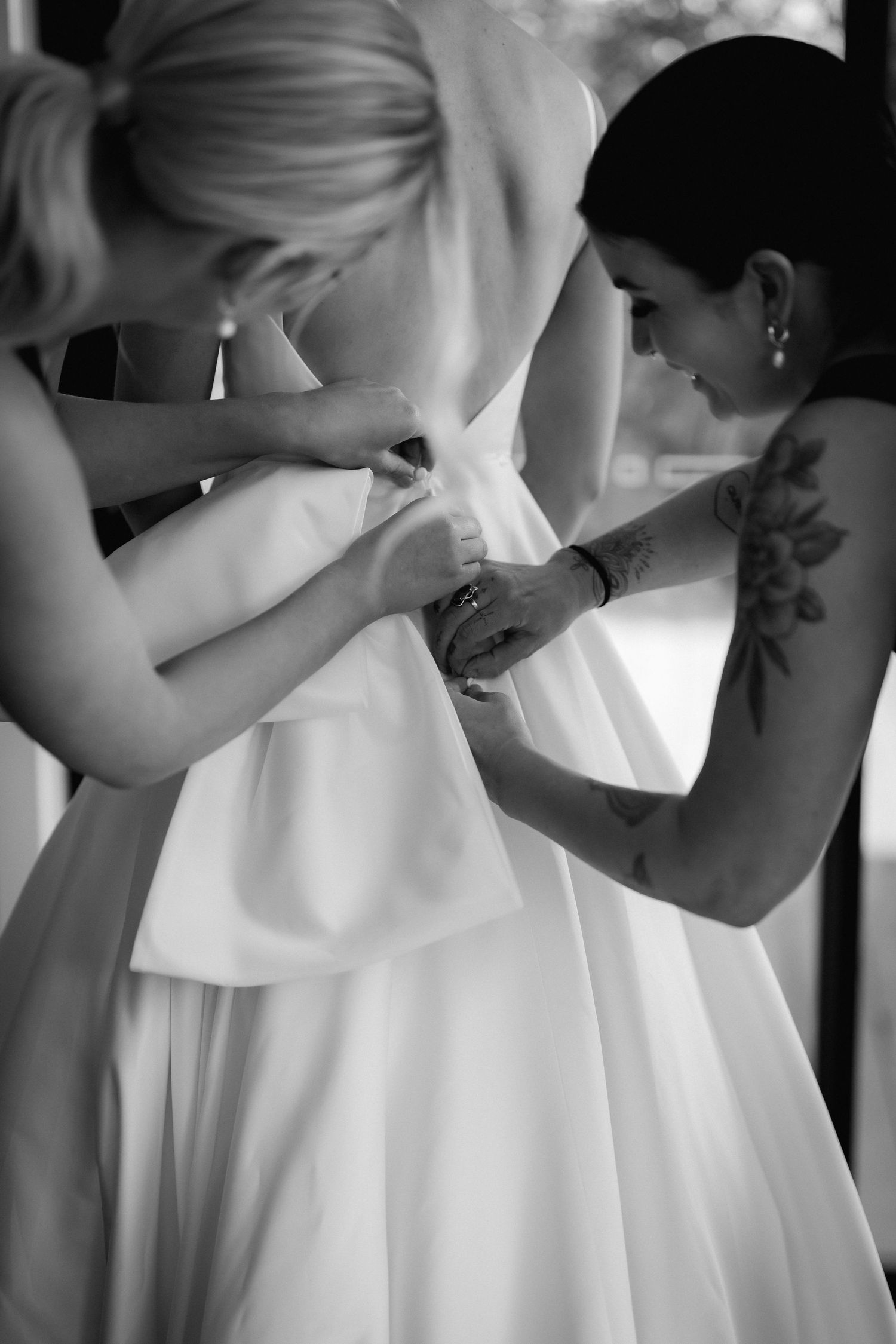 Close up black and white photo sequence showing the intricate details of lacing up a wedding dress.