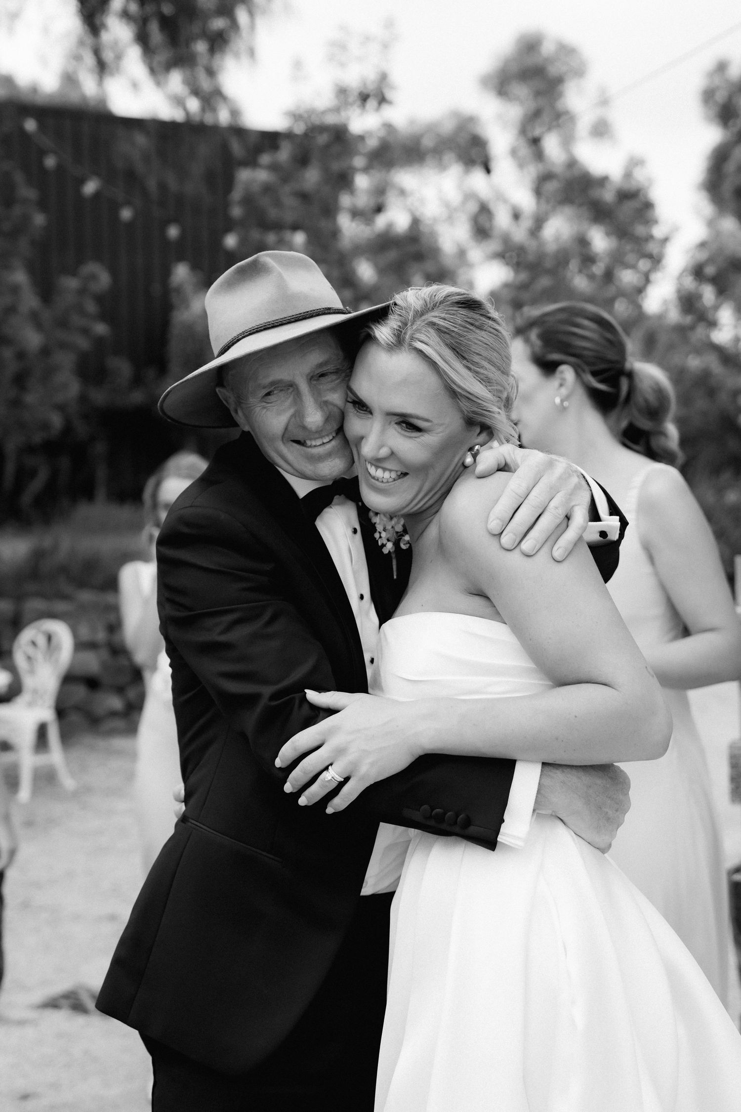 Joyful wedding moment captured in black and white as guests celebrate outdoors.