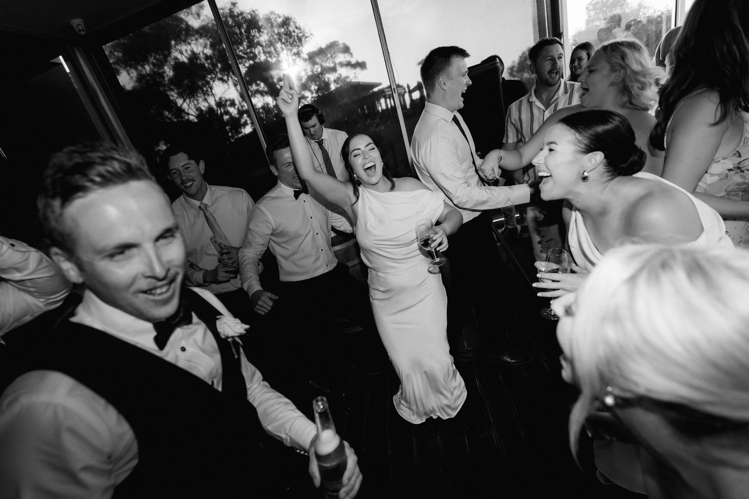 Black and white photo of energetic dancing at a wedding reception.