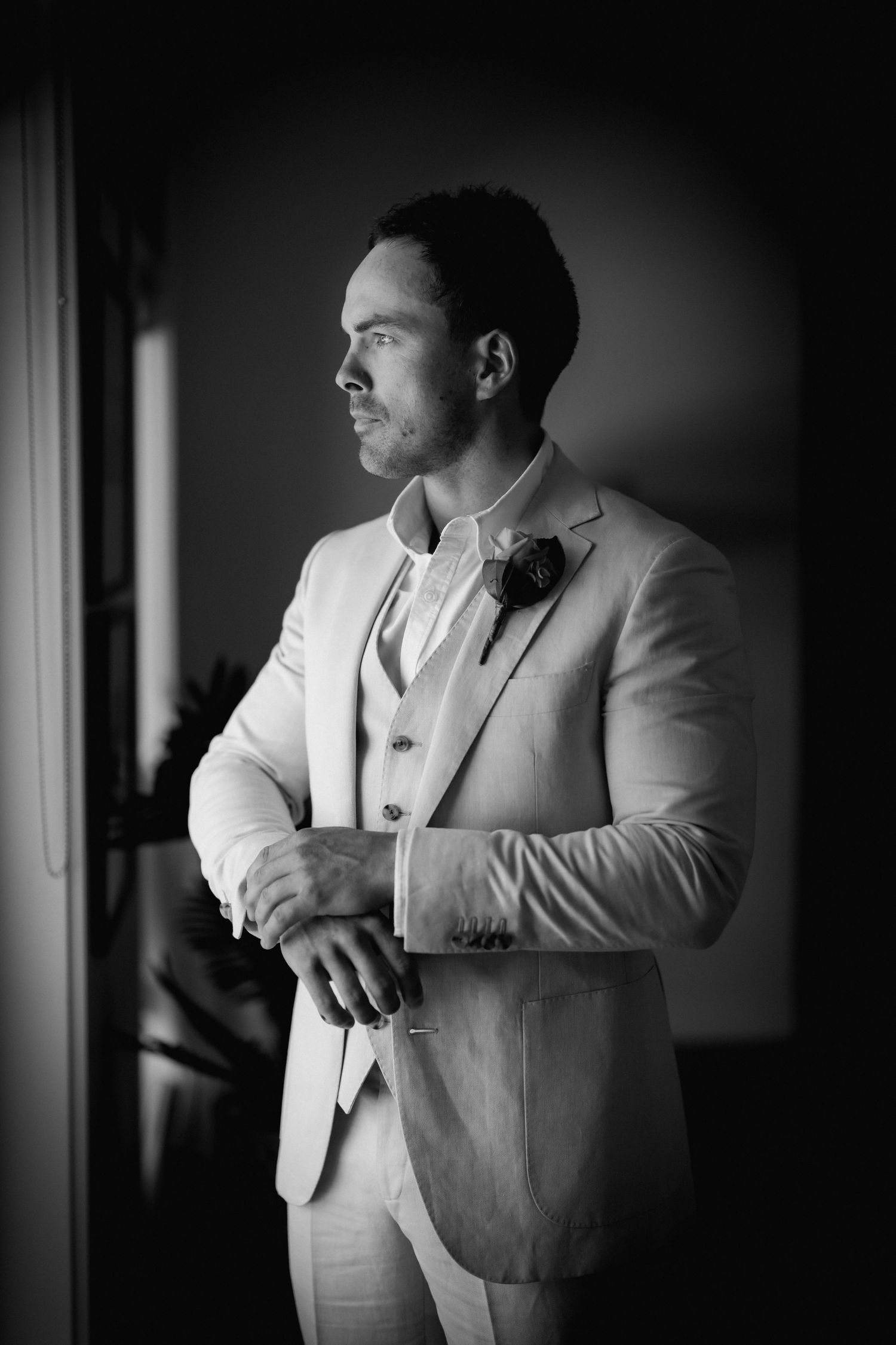 A series of black and white photos showing a groom adjusting his suit and cufflinks before the ceremony.