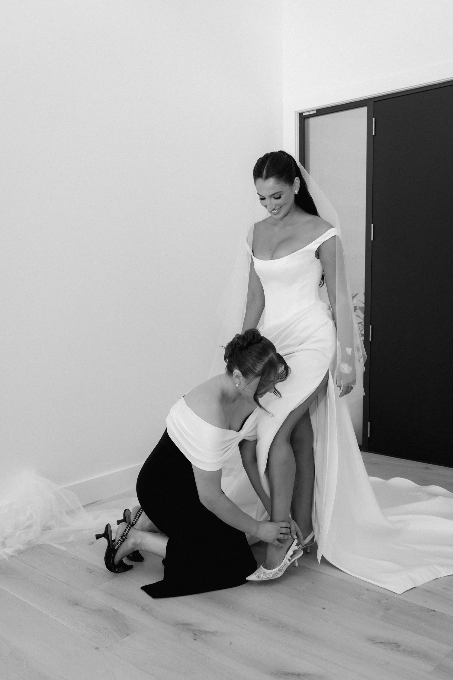 A sequence of black and white photos showing someone adjusting a white fabric or sheet on the floor.