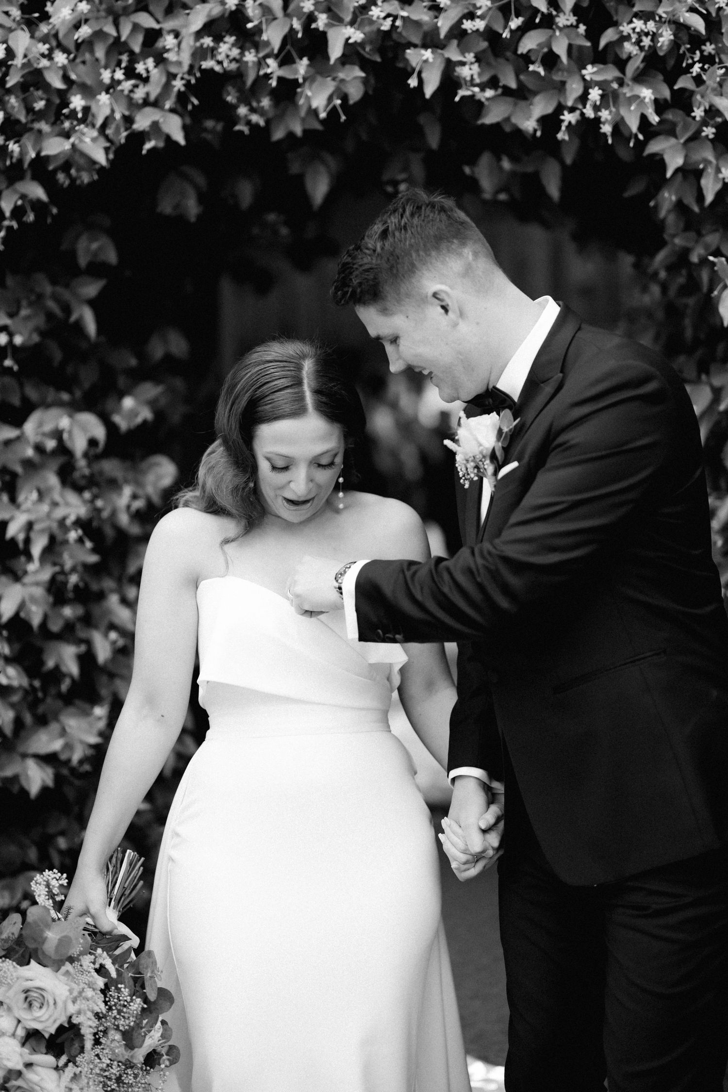Intimate black and white portrait of a couple on their wedding day against an ivy covered wall.