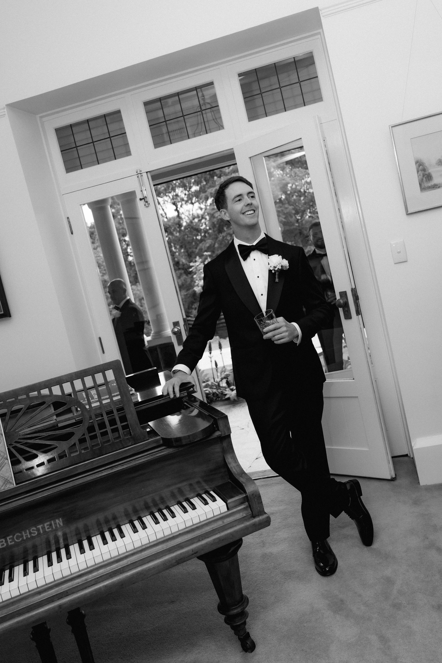 A black and white photo series showing a man in a tuxedo posing with a piano in an elegant room.