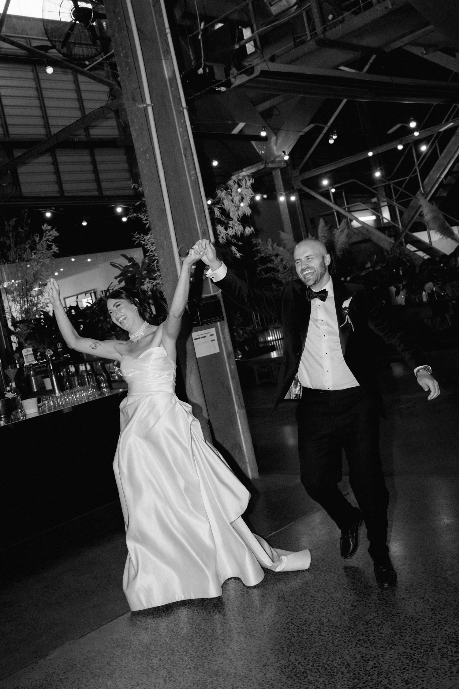 Black and white photos show couple dancing energetically at a wedding reception with flowing white dress.