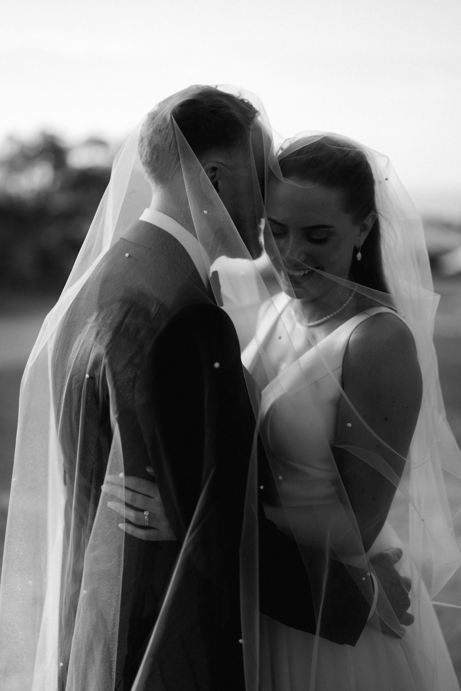 Artistic black and white veil portraits showing delicate movement and flowing fabric.