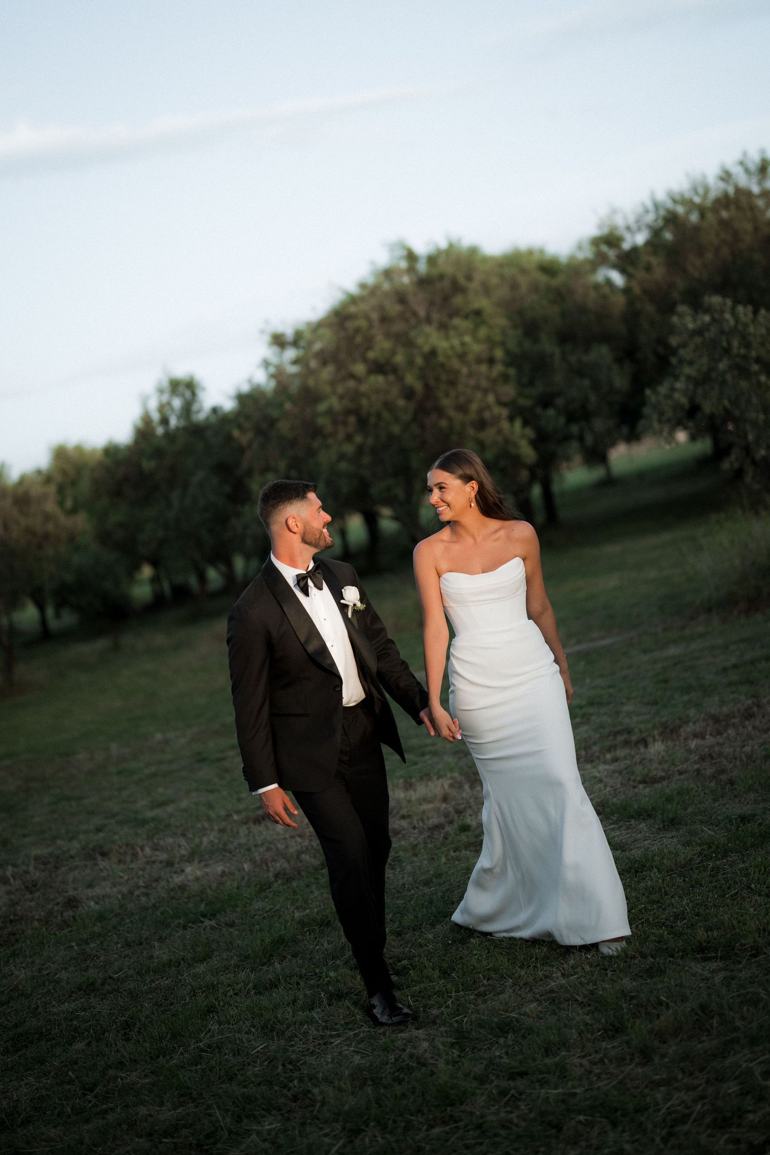 A playful wedding photo sequence captured on a grassy hillside during golden hour.