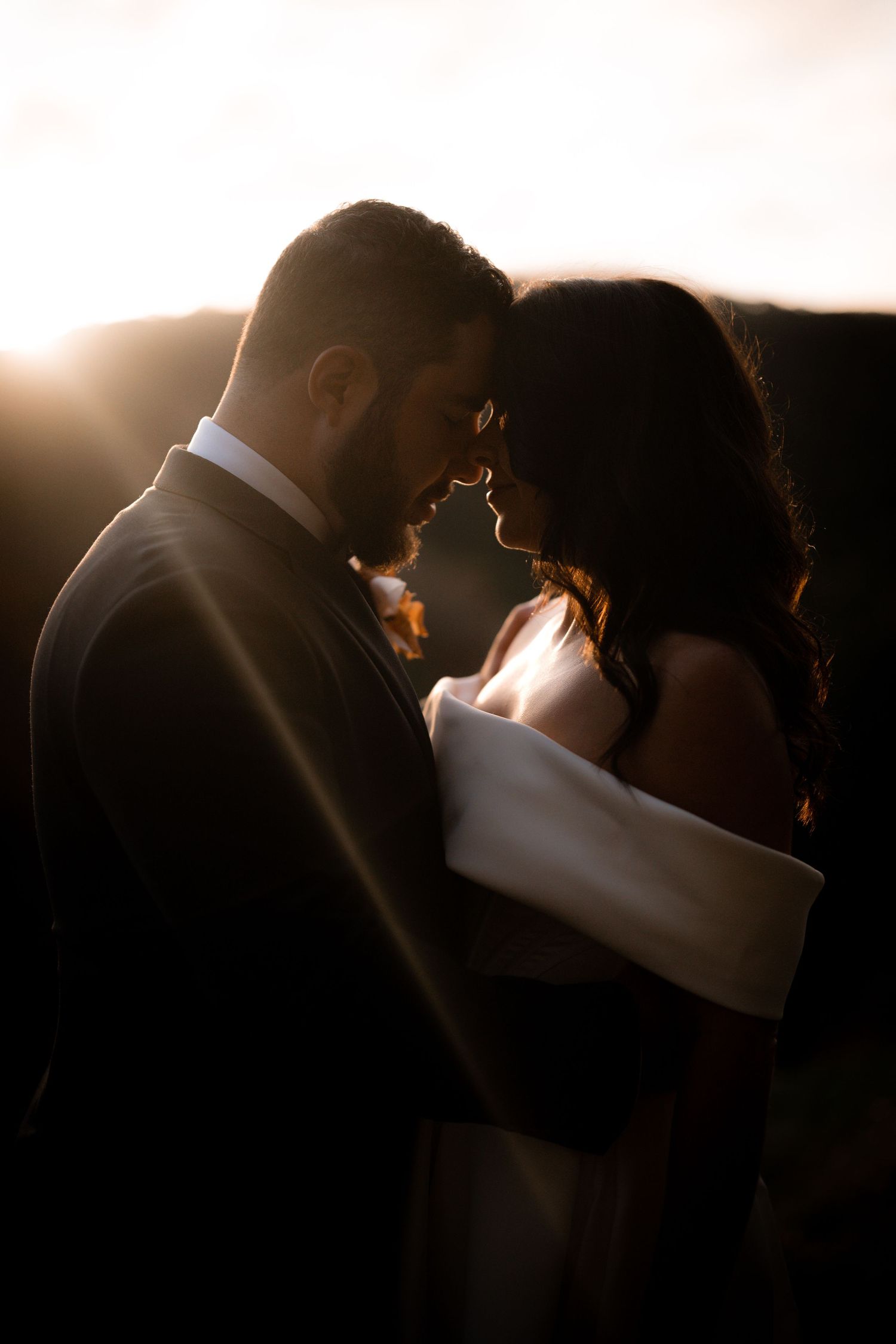 A romantic sunset silhouette of a couple in intimate embrace.