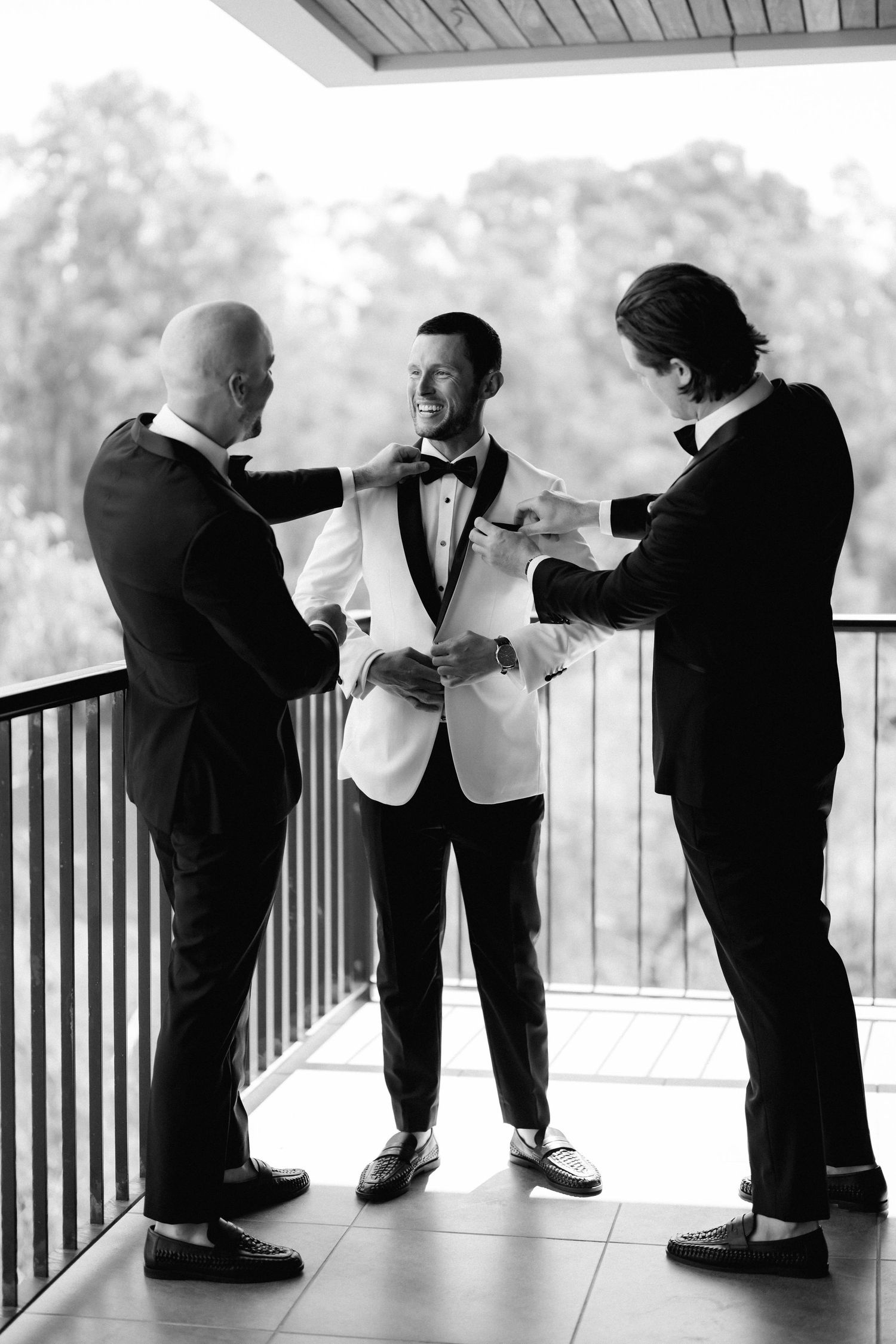 Black and white photo sequence showing groomsmen bowing in formal attire on a deck.