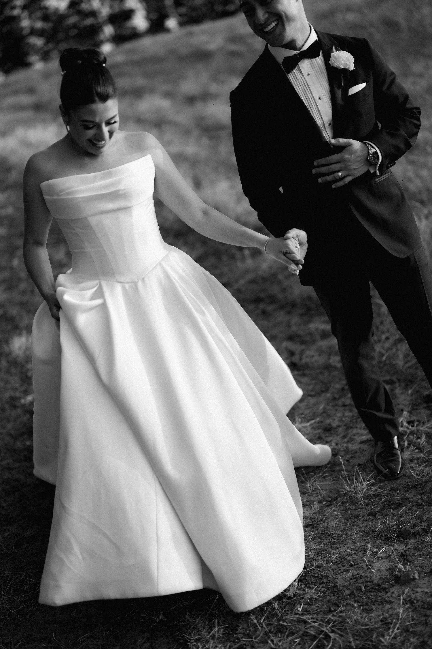 Black and white wedding photos showing playful moments with a bride in a classic white dress.