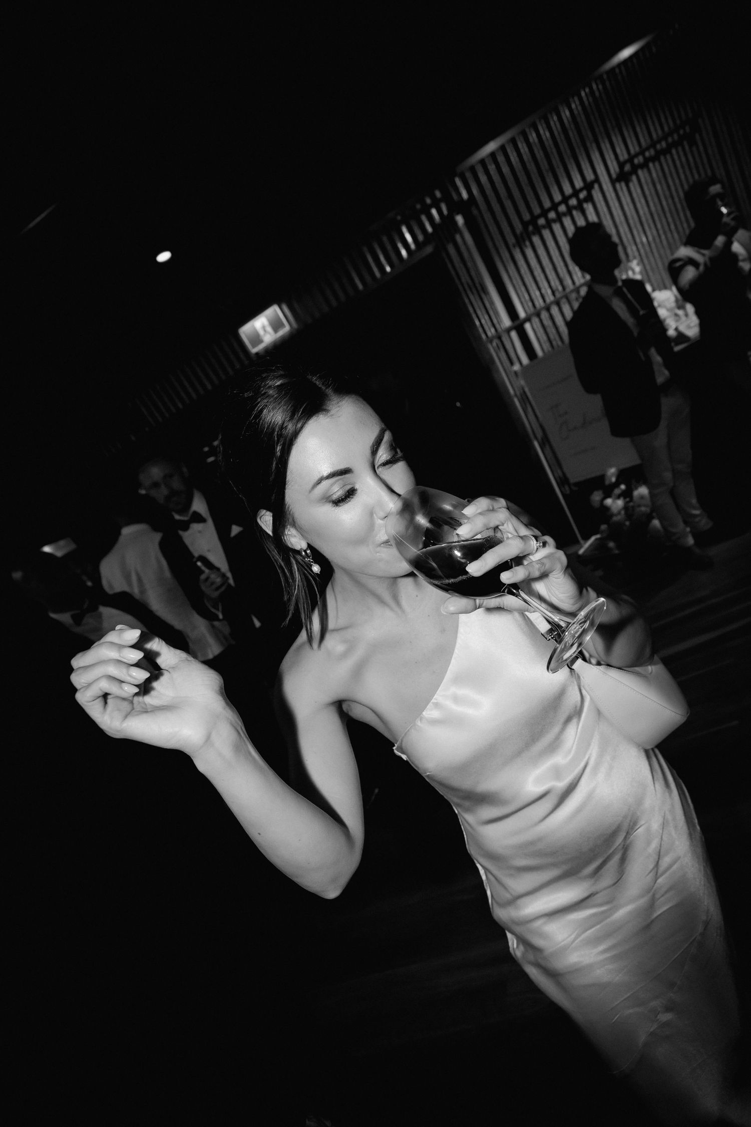 Black and white photos of wedding guests dancing energetically at reception party.