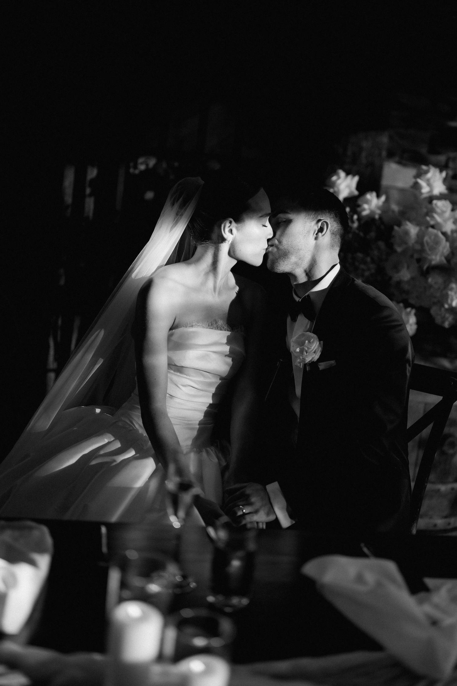 Intimate black and white wedding portraits in dramatic lighting.