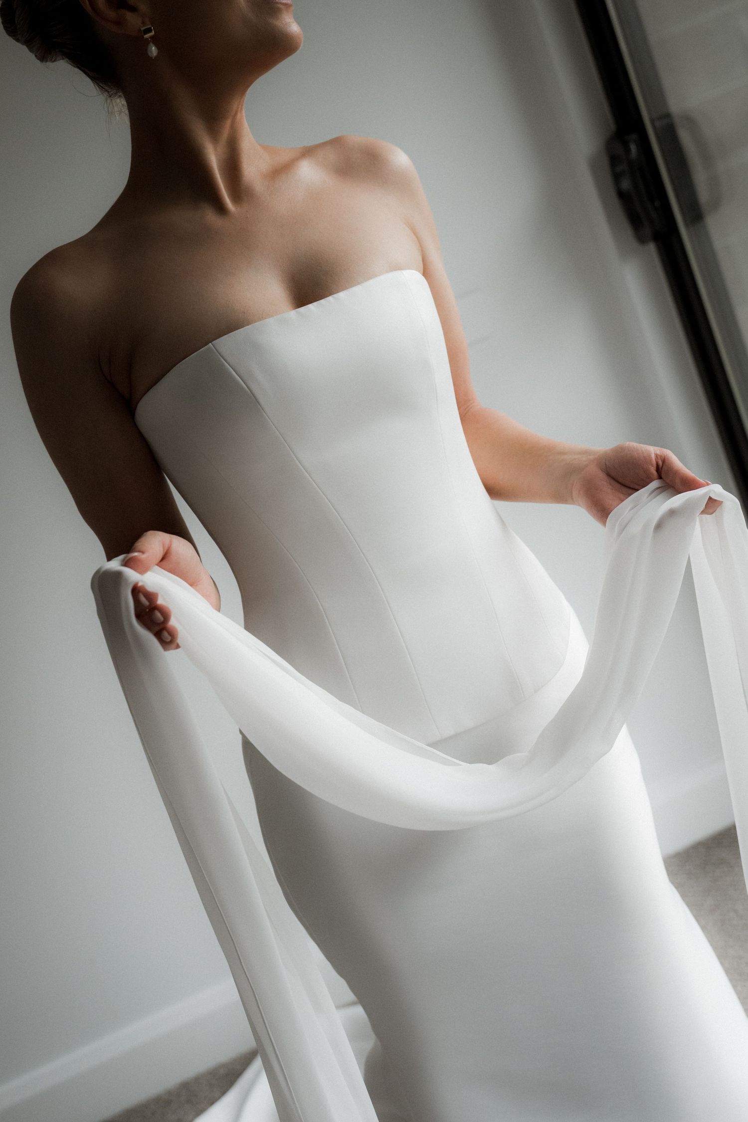 Close-up details of an elegant white strapless wedding dress in multiple angles.