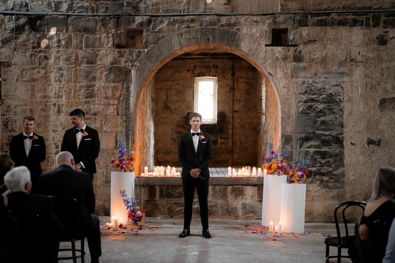 Stone castle interior illuminated with romantic candlelight for an intimate wedding ceremony.