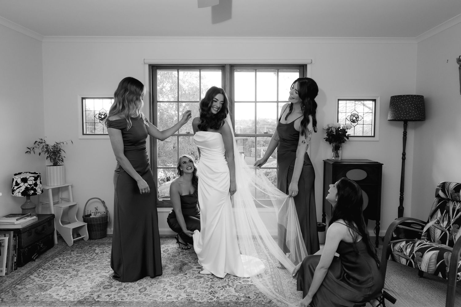 Black and white panoramic photo sequence showing wedding preparation moments in a bright sunlit room.