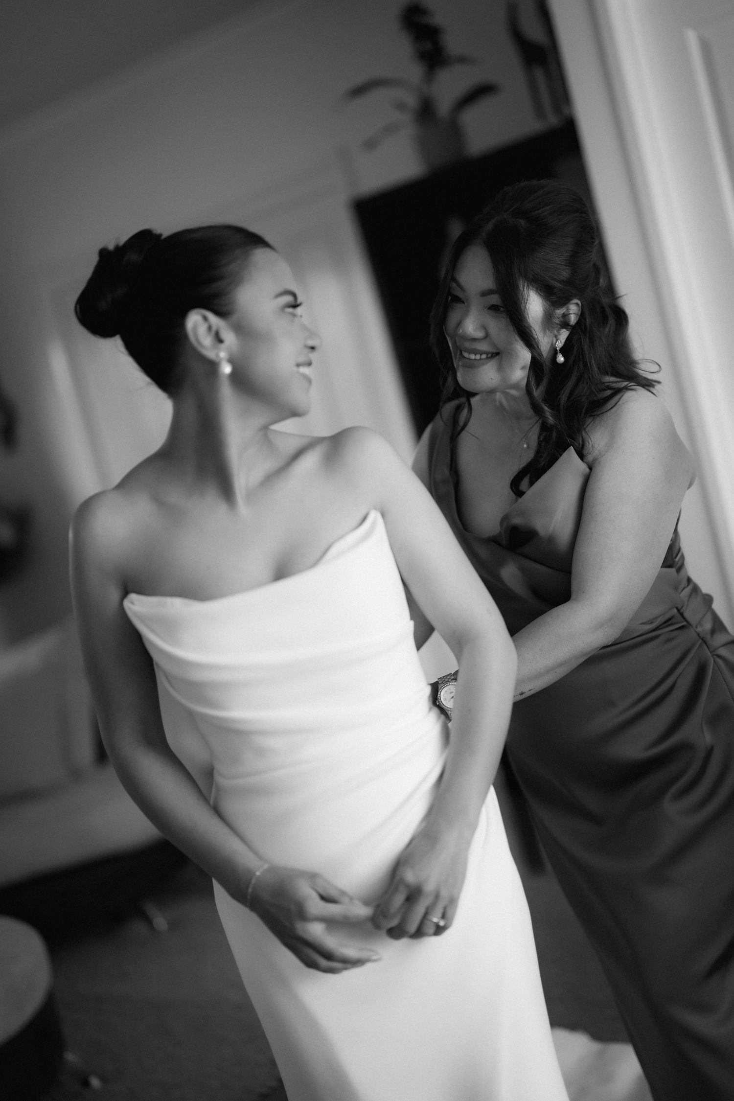 Black and white sequence showing bride getting ready with bridesmaids in elegant strapless gown.