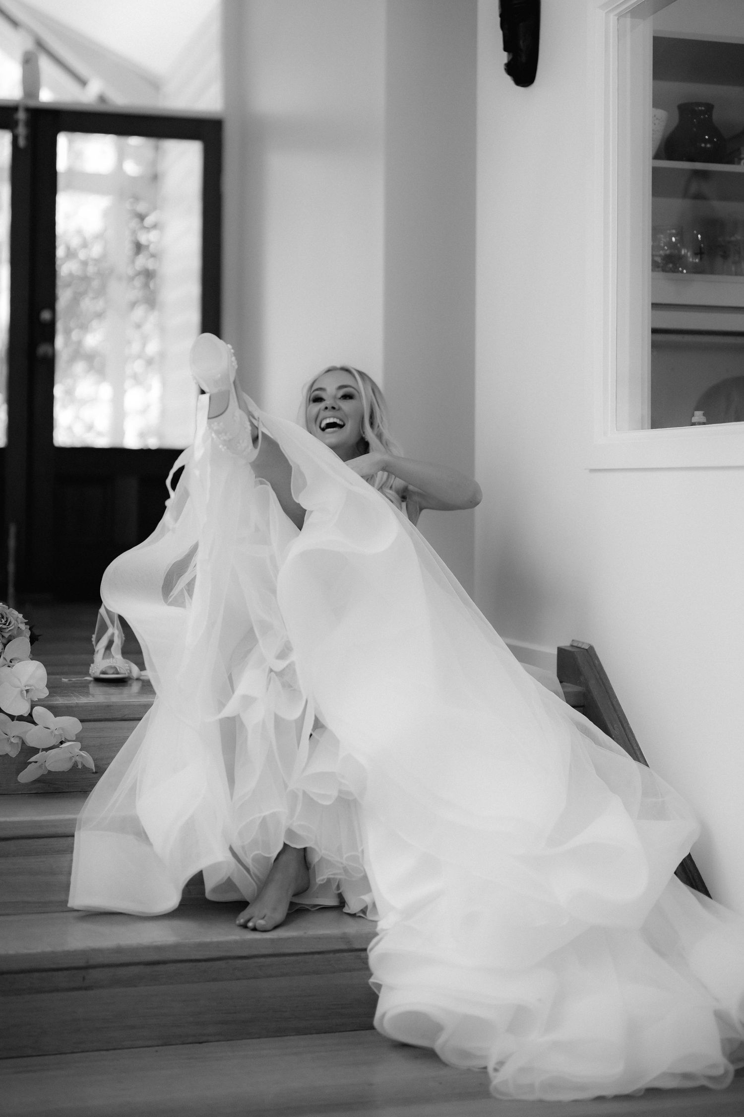 A flowing white wedding dress creates a dynamic movement sequence across a wooden floor.