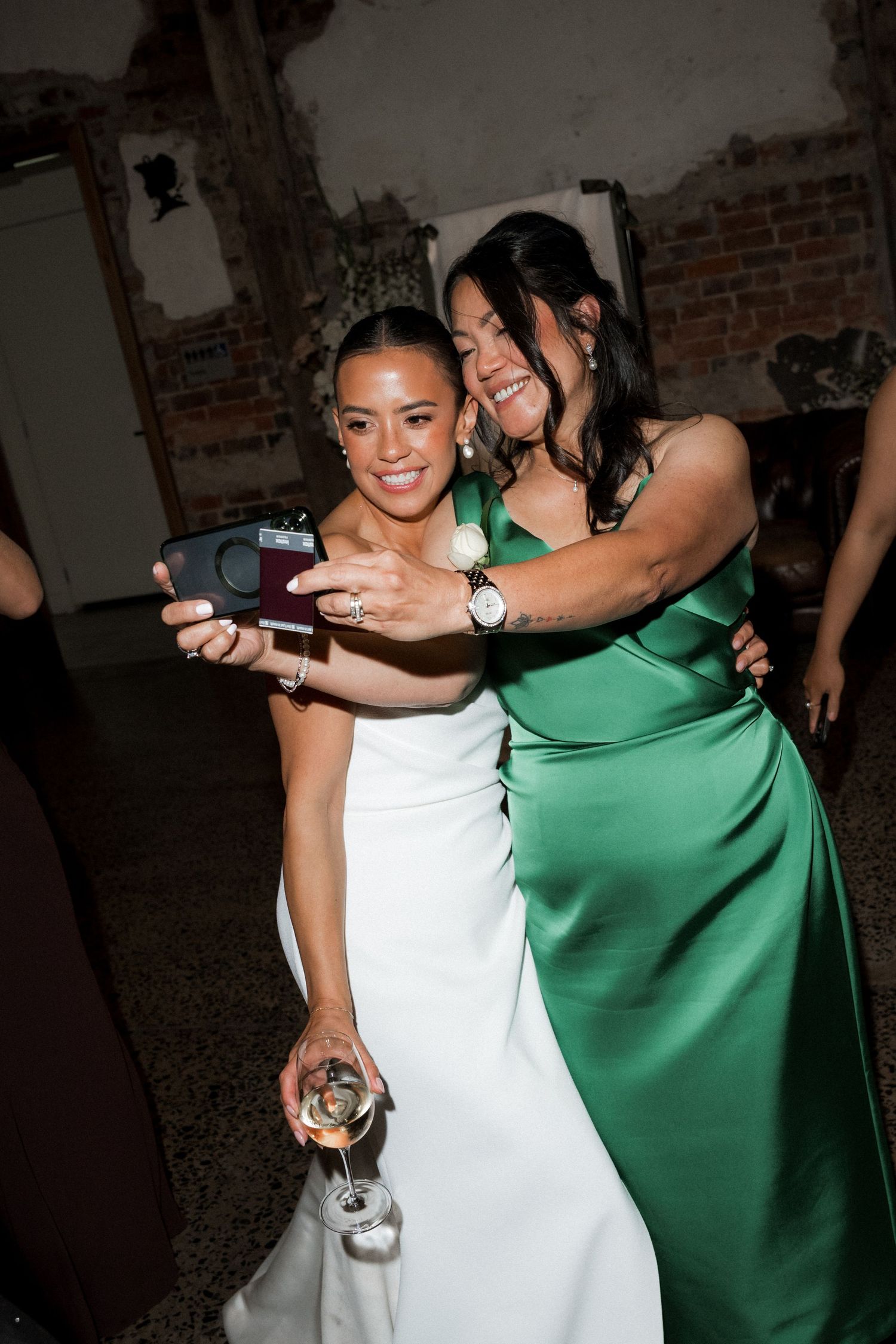 Wedding celebration with guests in white and green dresses dancing and holding champagne glasses.