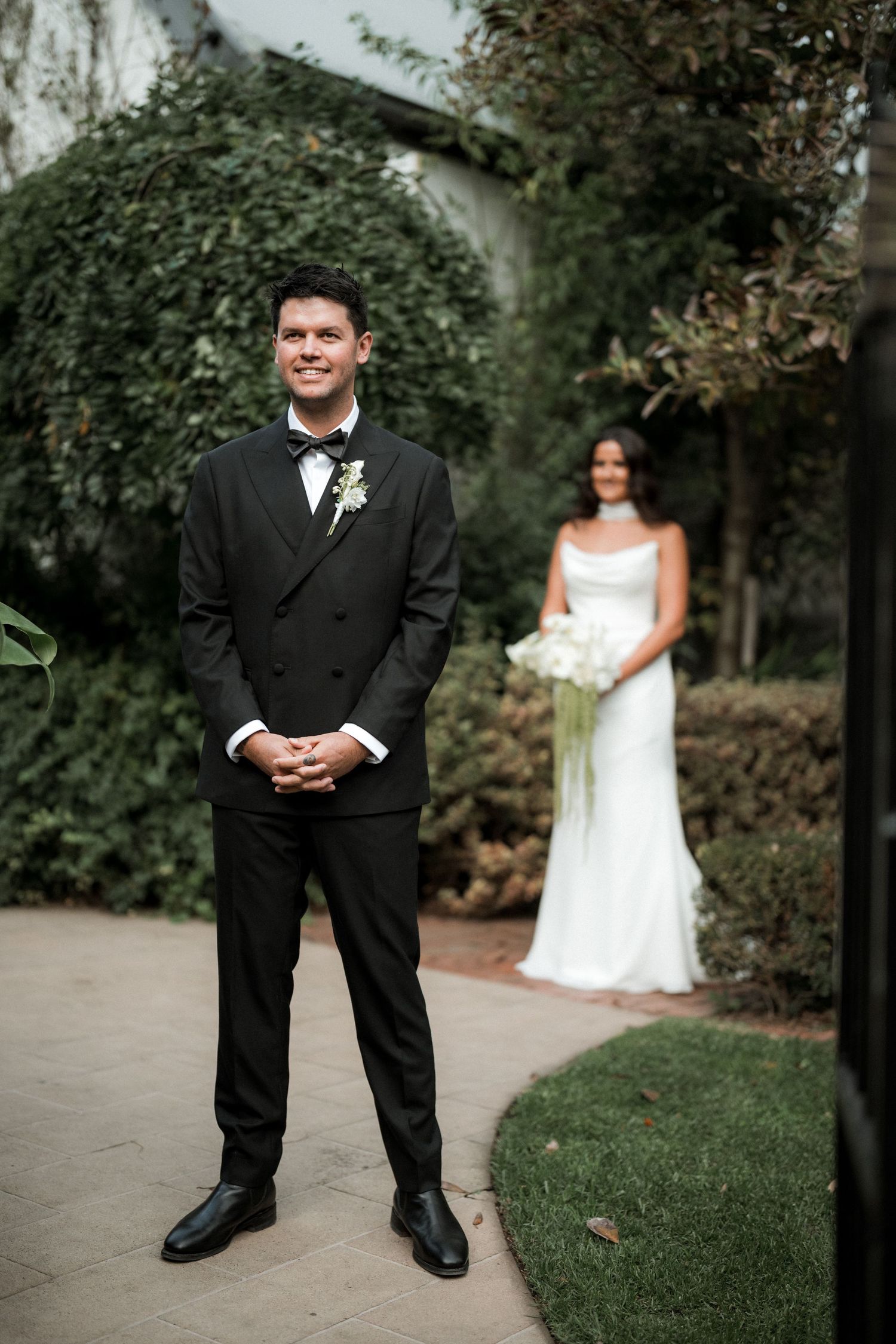A series of wedding photos showing a person in a black tuxedo and someone in a white dress in a garden setting.