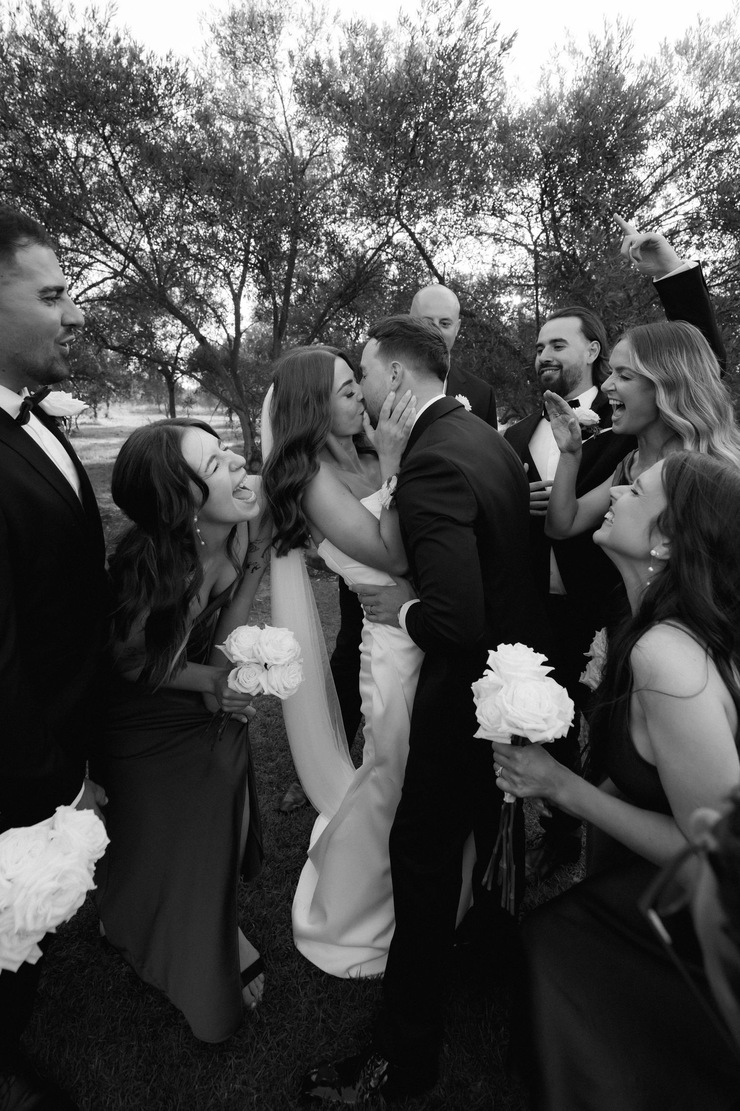Black and white sequence of wedding guests toasting and drinking champagne outdoors.