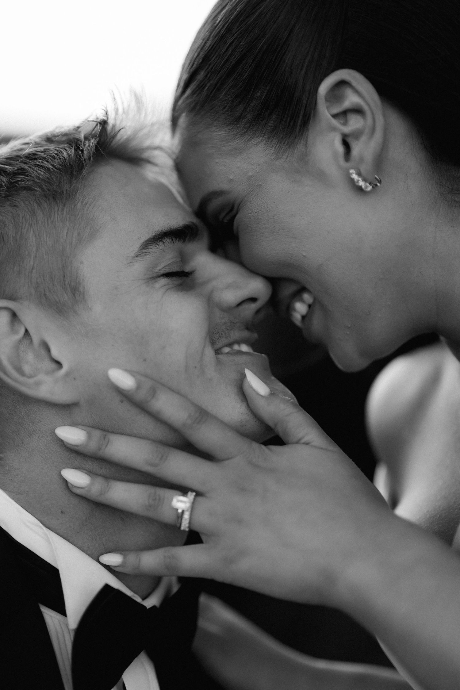Intimate black and white close-up of tender moment between newlyweds.