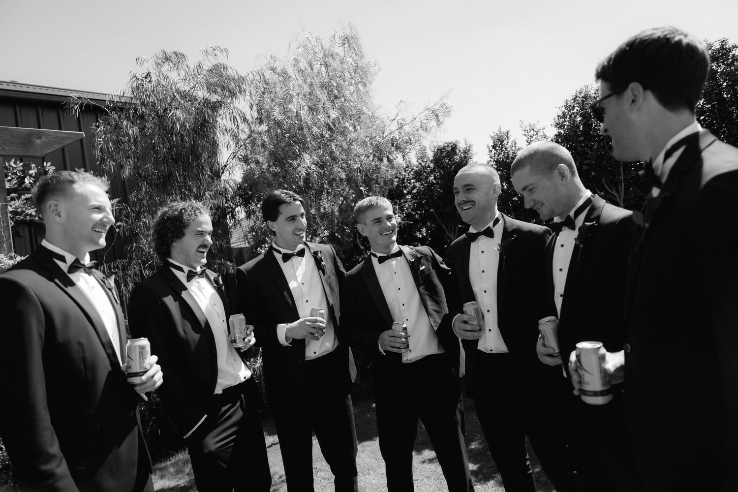A black and white photo of a group of formally dressed people standing together in conversation.