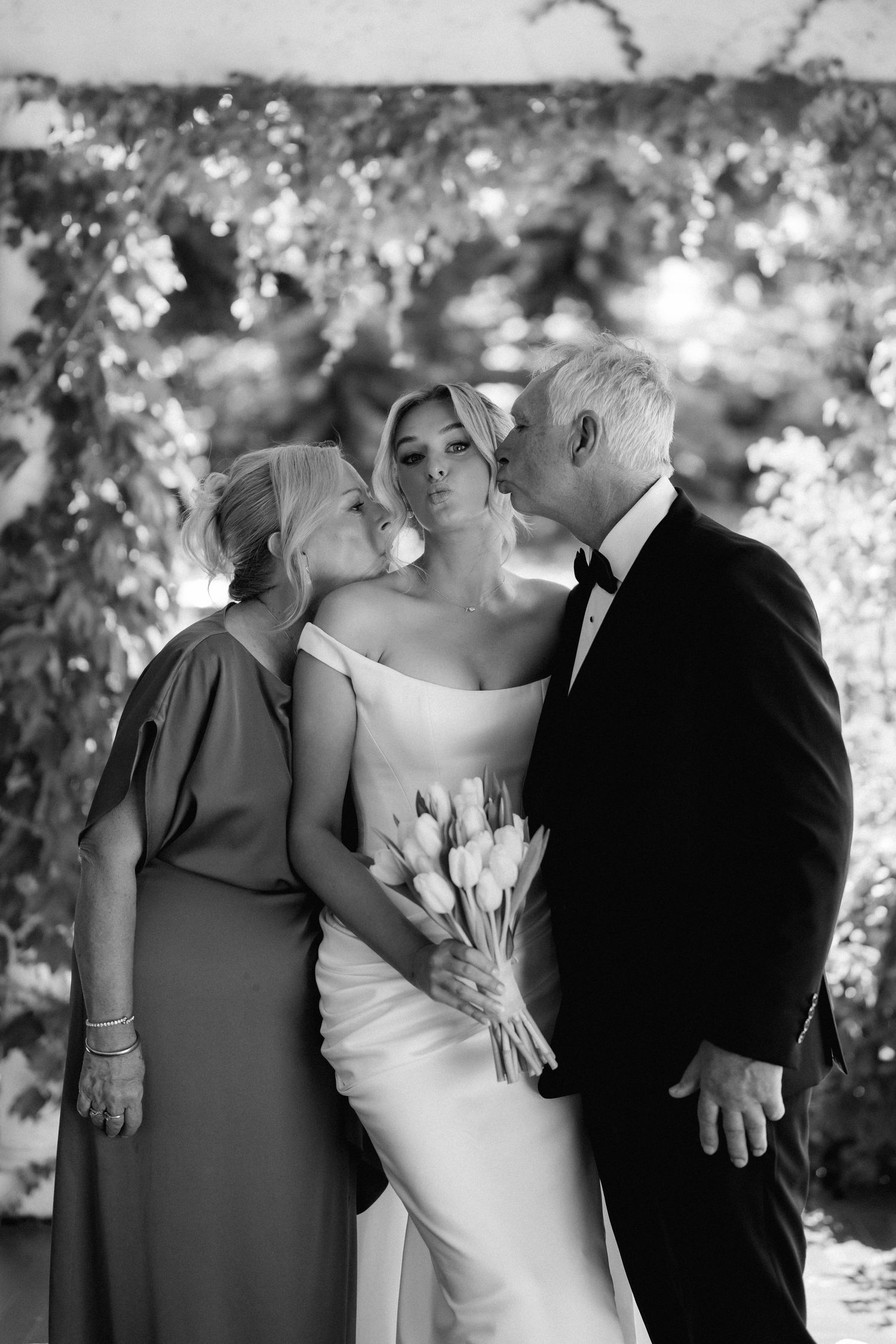Intimate wedding portrait taken outdoors with bokeh effect in background.