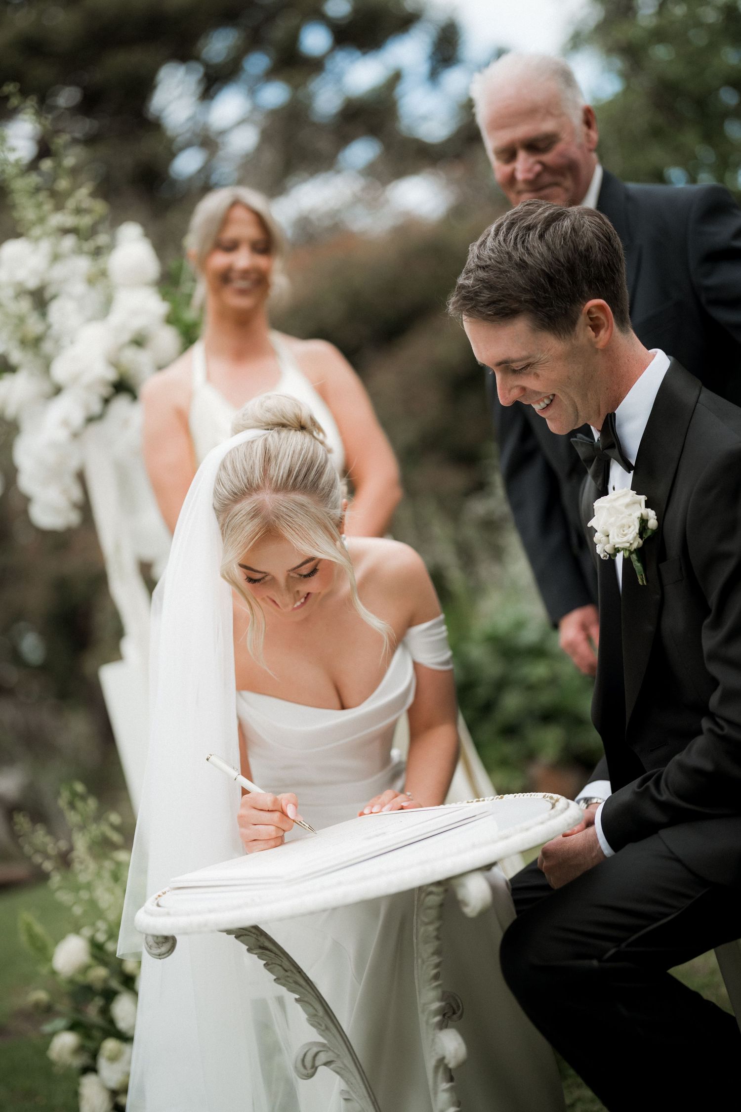A series of candid wedding moments showing a couple signing documents together outdoors.