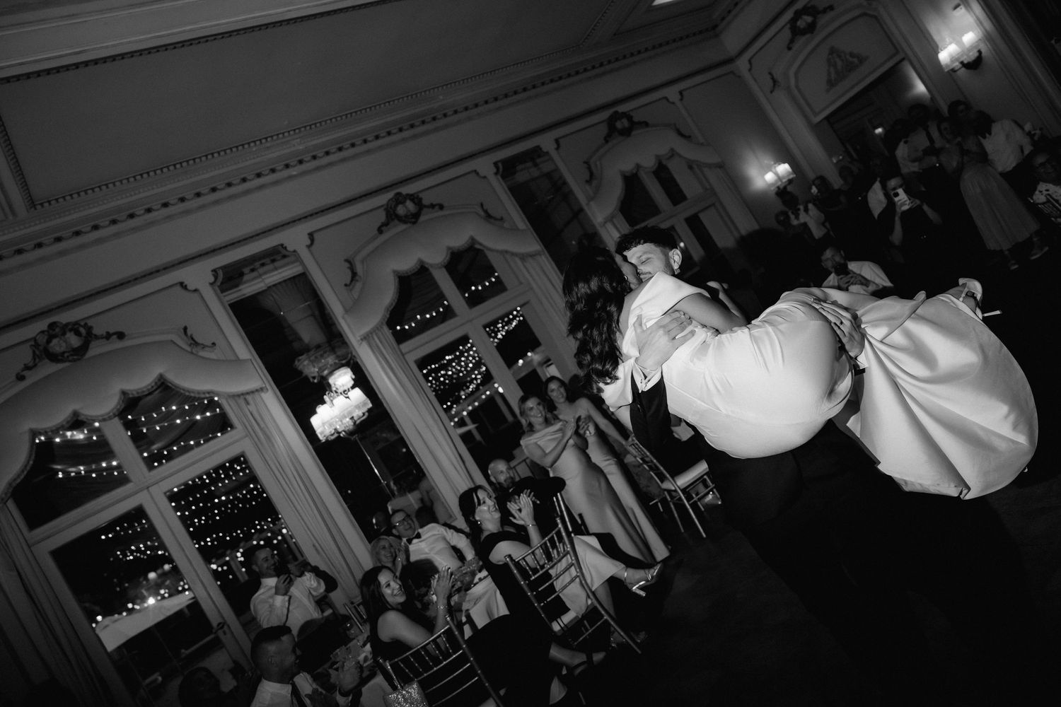 A wedding reception with a high-angle view showing a crowd gathered in an elegant ballroom with ornate architecture.