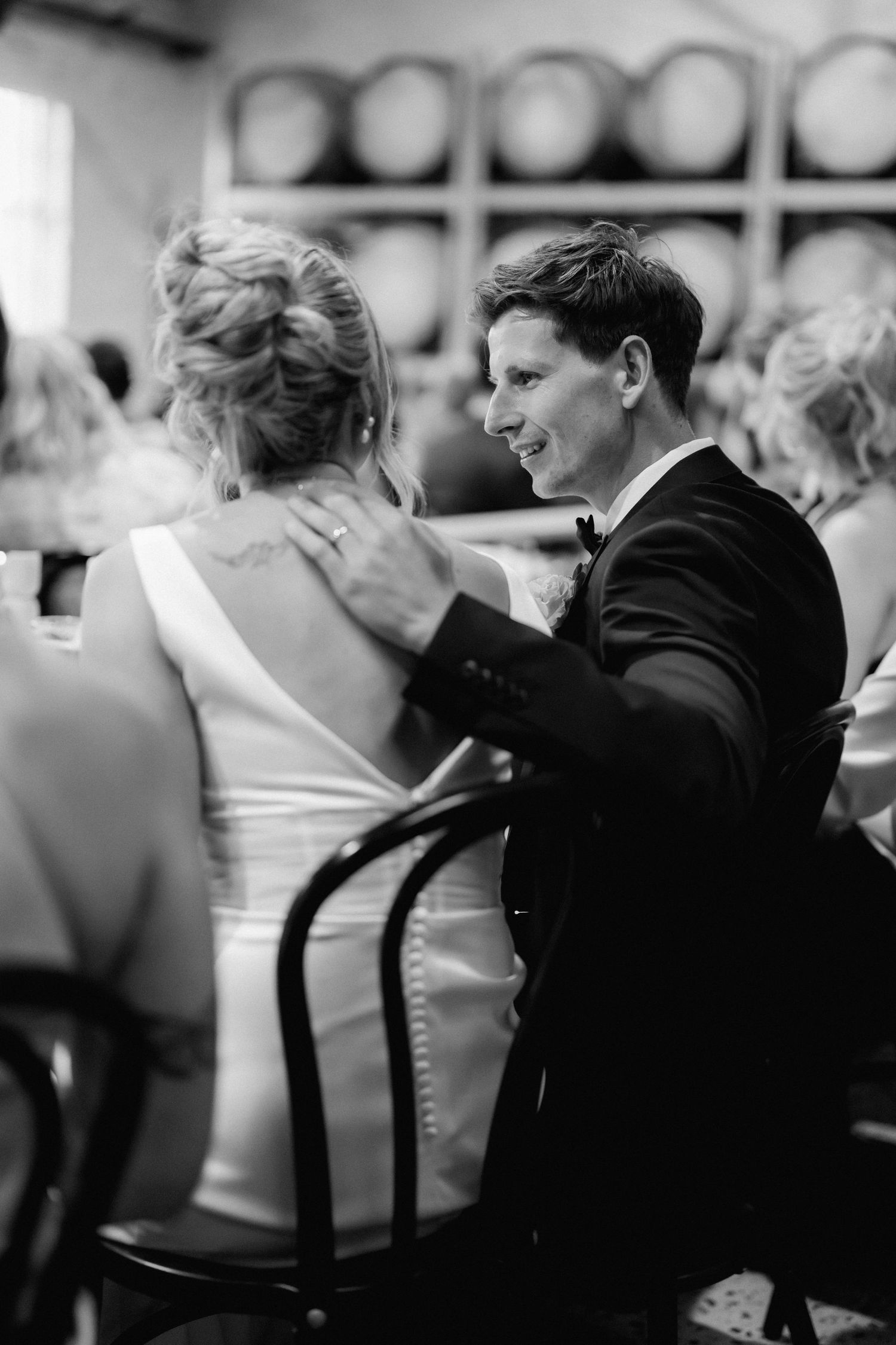 A tender black and white wedding reception moment captured between dancing partners in formal attire.