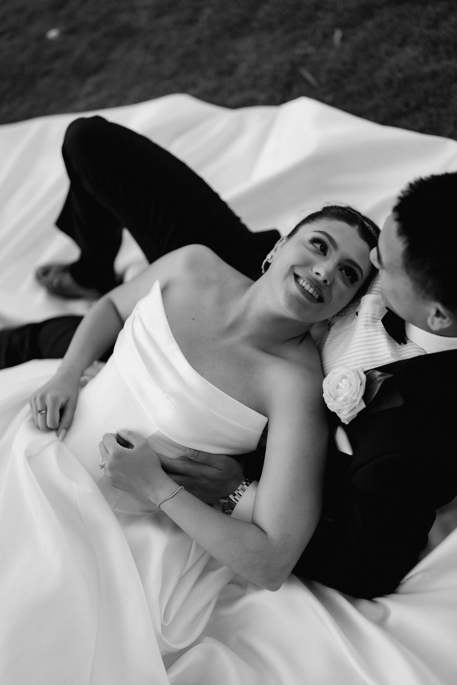 Artistic black and white close-up of couple in wedding attire.