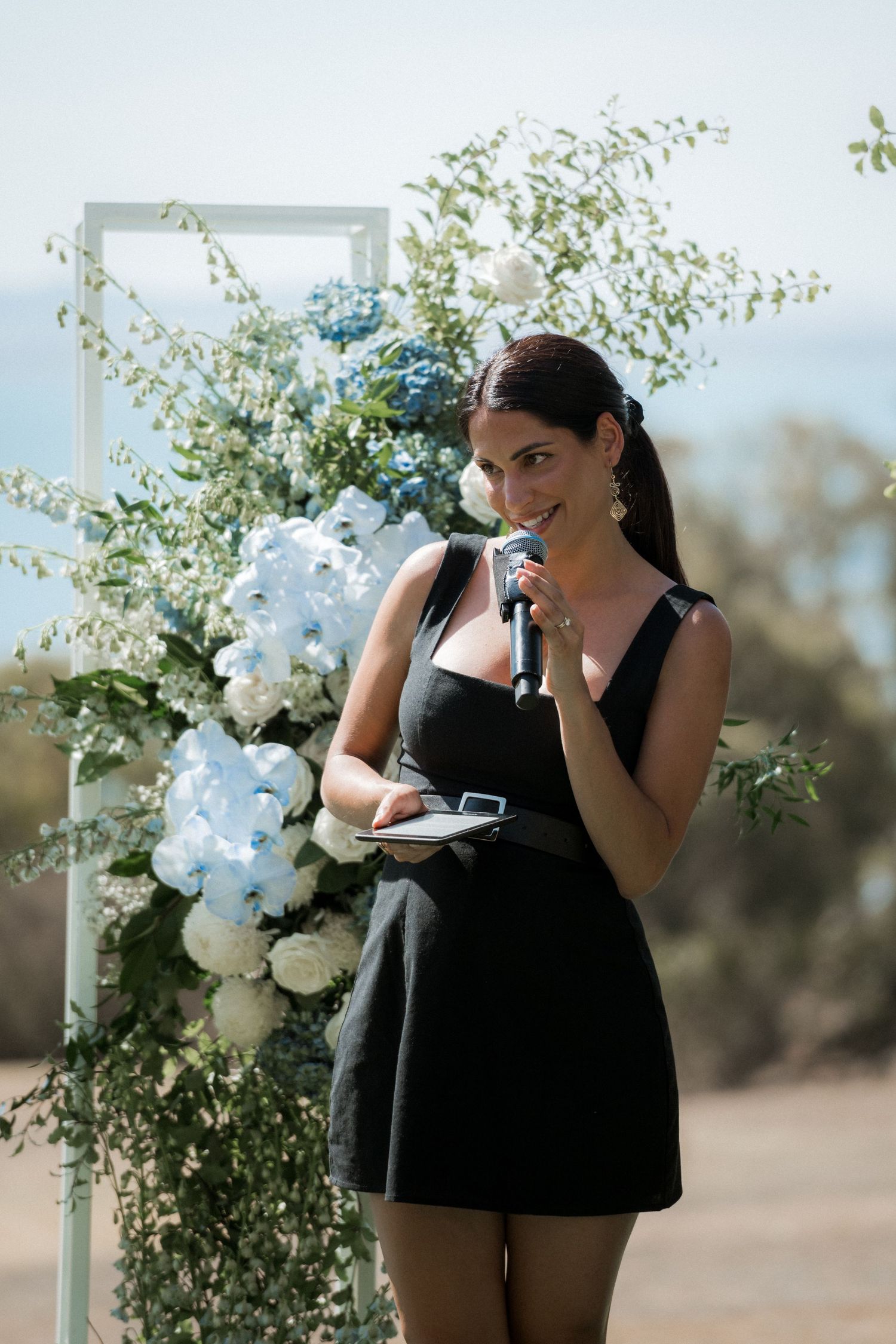 Wedding photographers in black attire capture moments near floral arrangements.