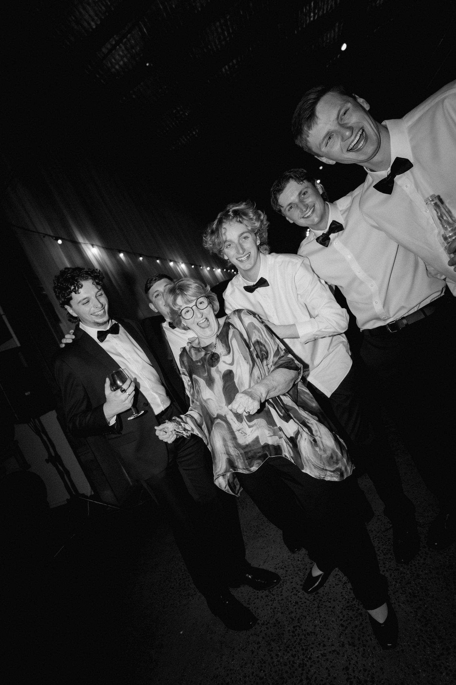 A group enjoying themselves on the dance floor at a formal black and white event.