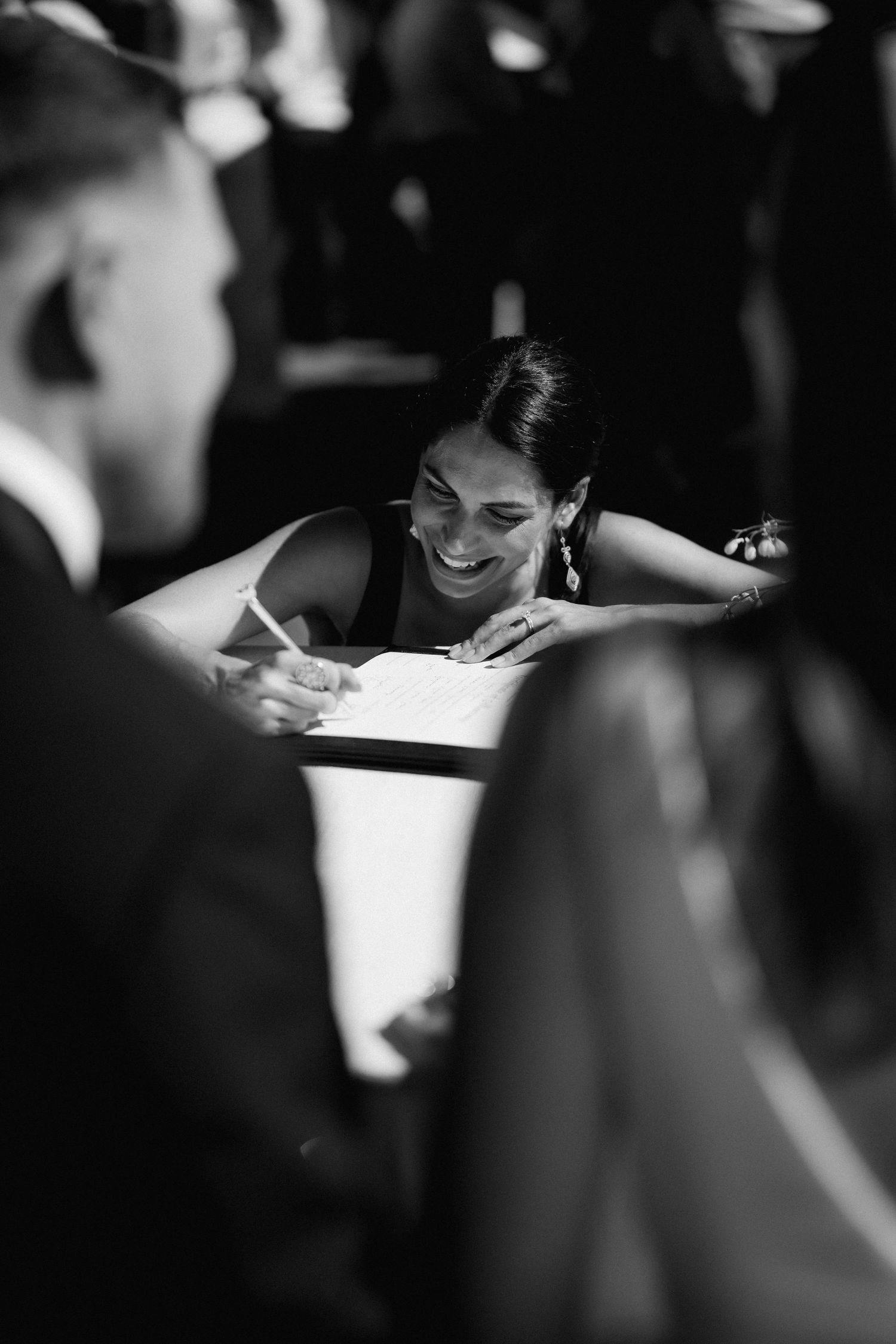 Black and white photo of guests signing the wedding guestbook.
