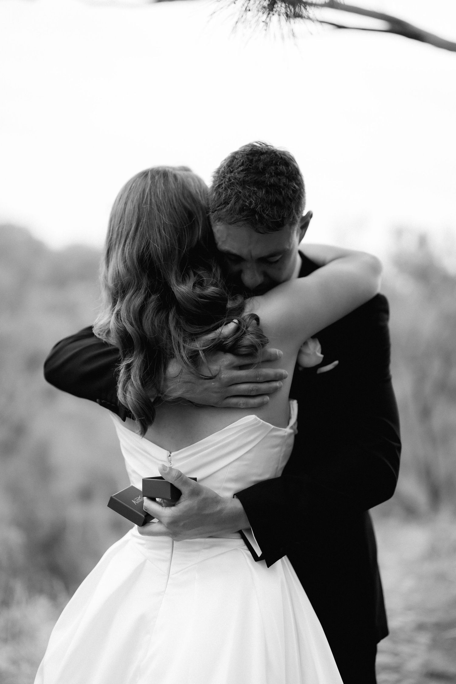 Intimate black and white wedding portrait captures a romantic embrace.