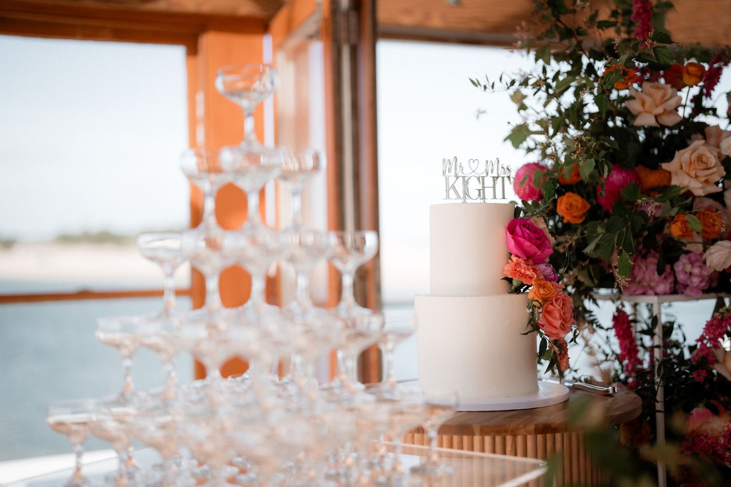Wedding reception table setting with glowing candles and floral arrangements in warm lighting.
