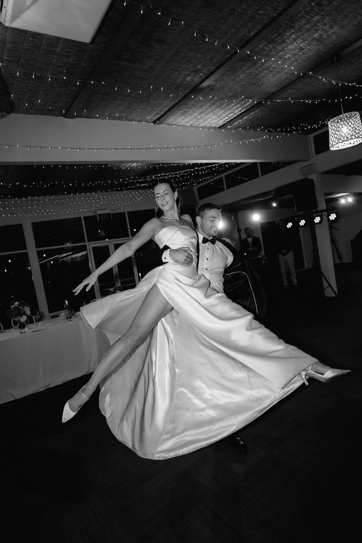 Black and white sequence of a wedding couple's dramatic dance moves under twinkling lights.