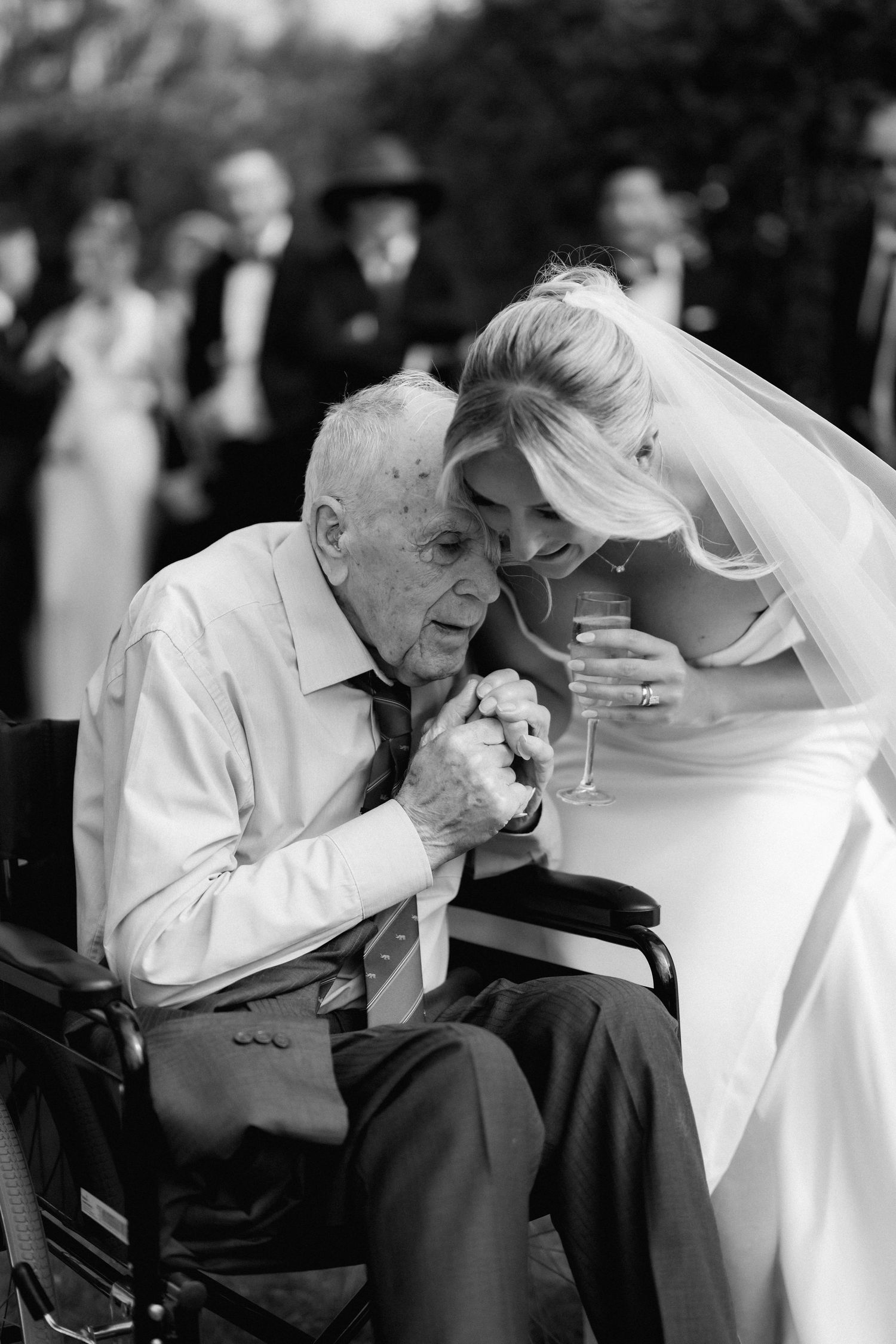 Emotional black and white wedding moment captured during outdoor celebration.