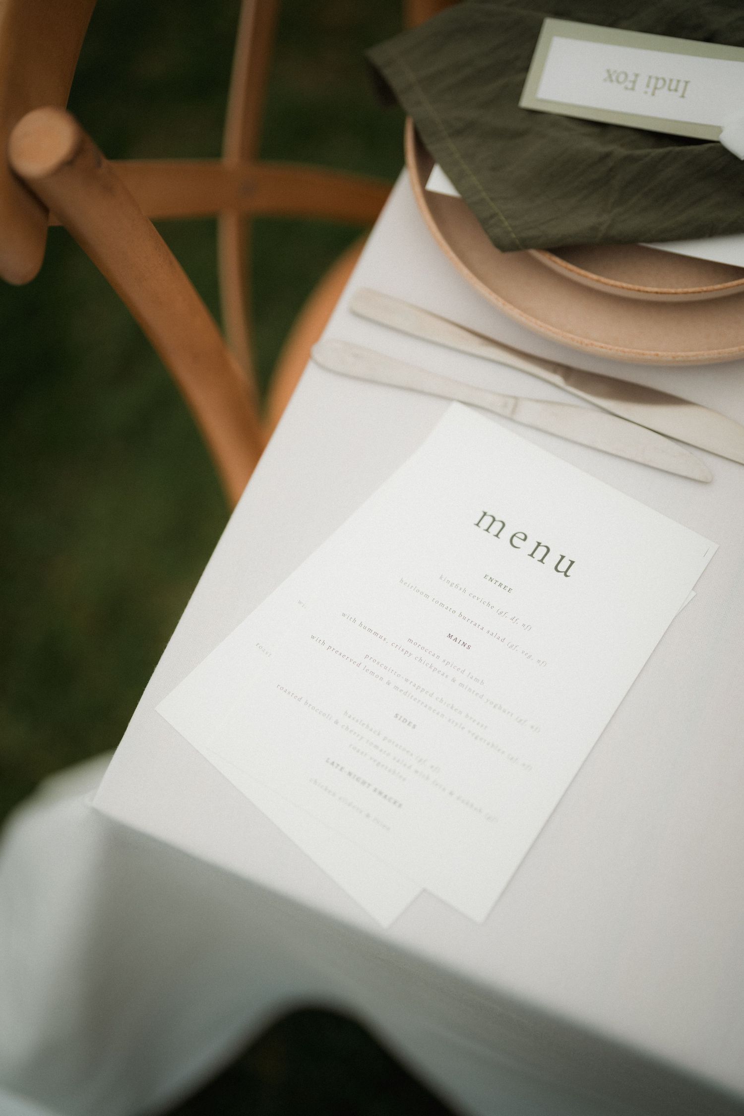 Simple white menu card displayed on a table setting with minimal design elements.