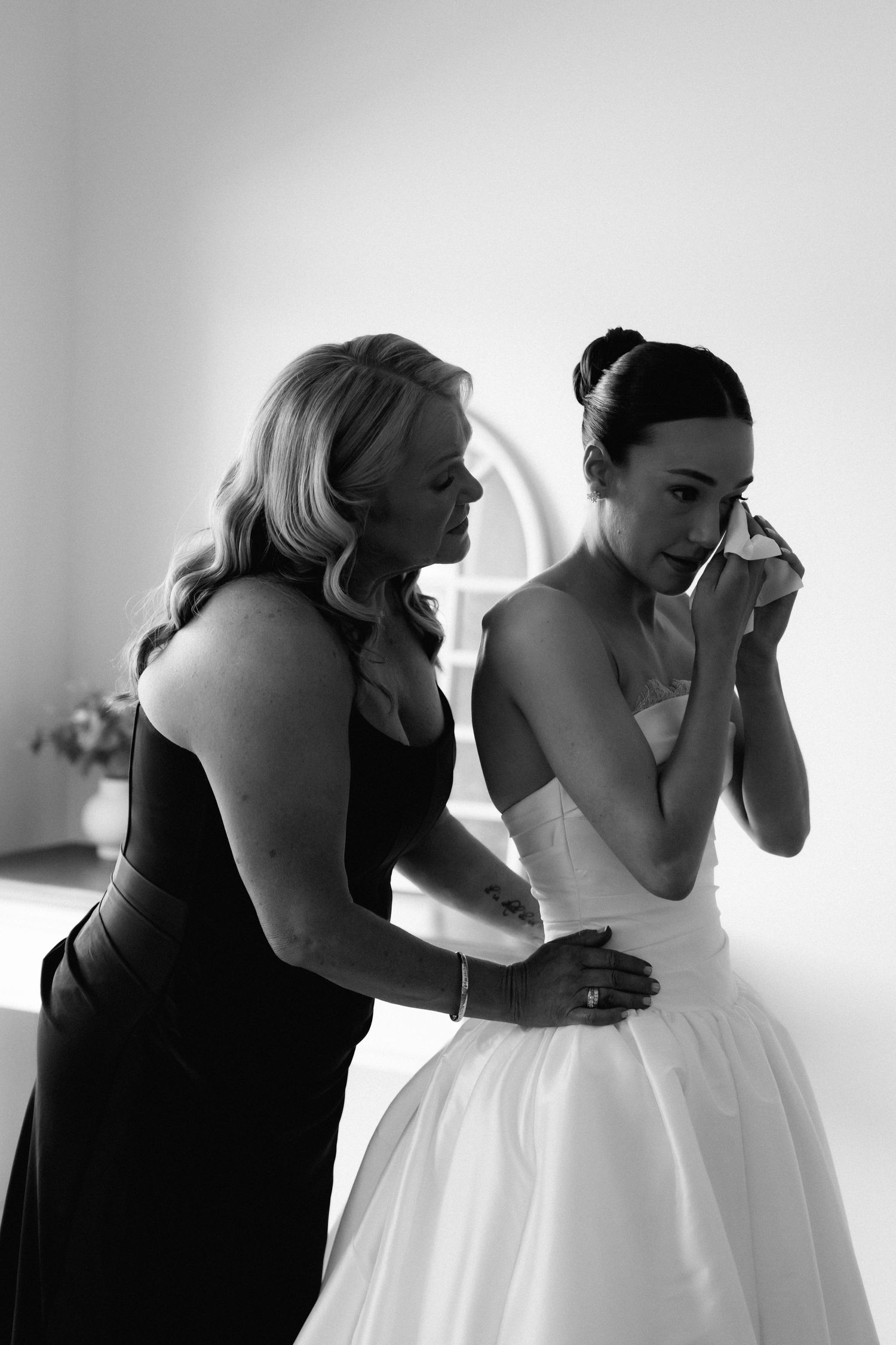 Black and white sequence showing emotional moment between two women in formal attire.