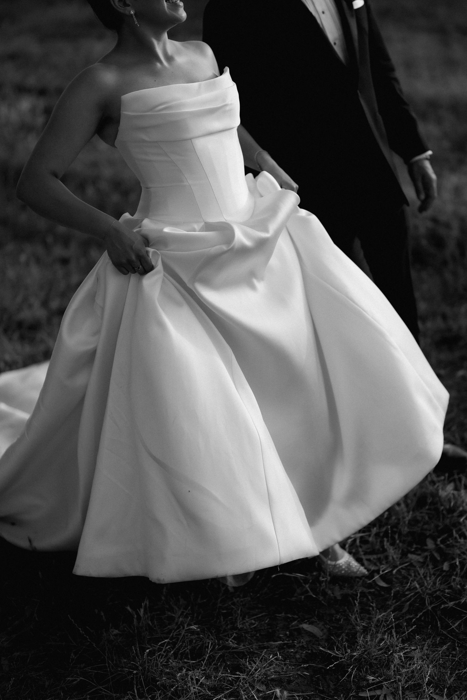 Close-up details of white wedding dress fabric in dramatic black and white.