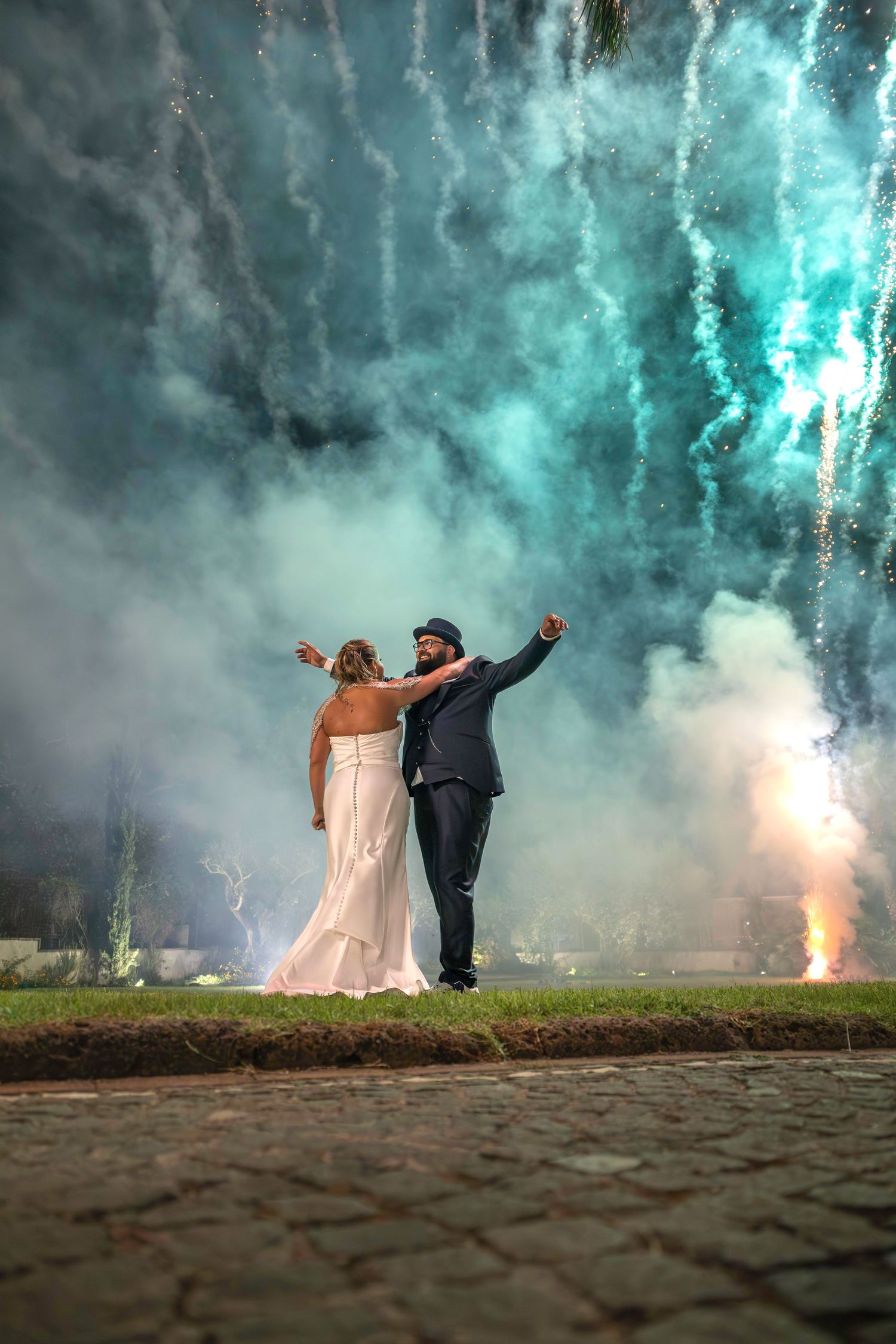 Bride and groom celebrating against a spectacular fireworks display at a wedding in Naples, Italy, wedding photography