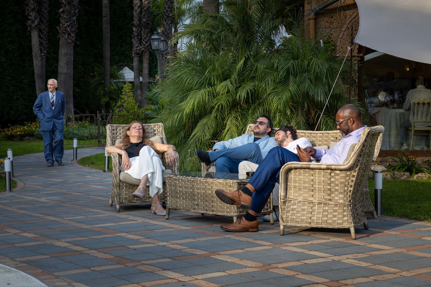 Candid shot of wedding guests relaxing in the sun between dinner courses at an outdoor wedding reception in Naples, Italy