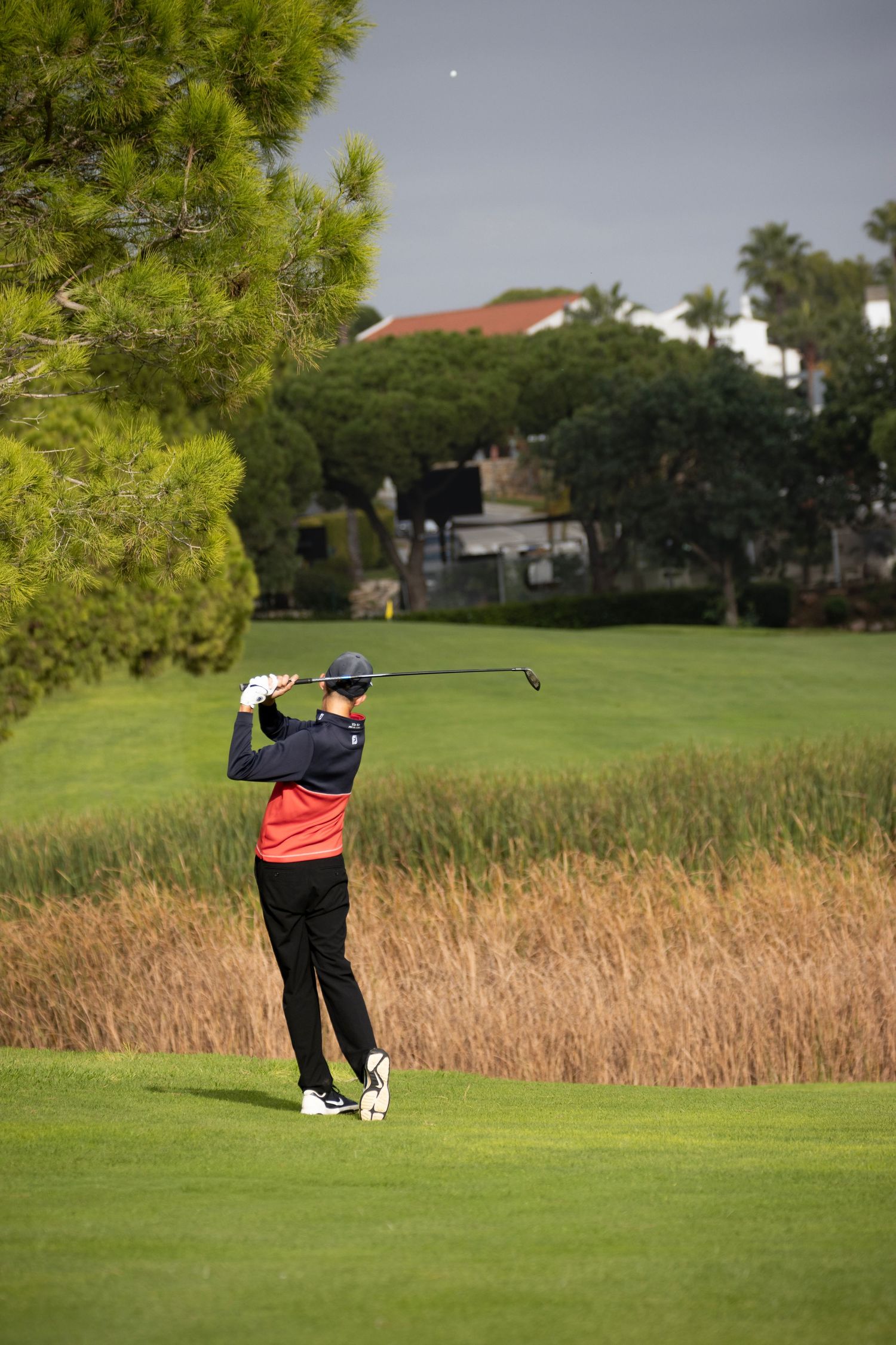 Golfer playing an approach shot on a lush fairway in the Algarve, Portugal golf action photography