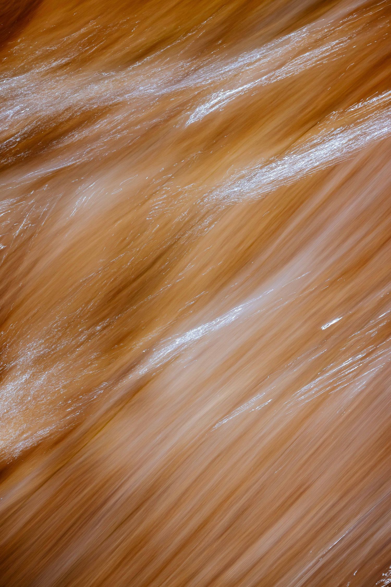 Abstract fine art photograph of water flowing over golden sand on an Algarve beach, Portugal