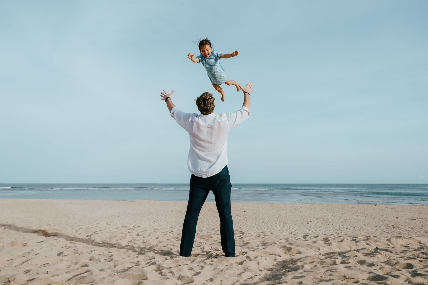 A heartwarming scene of play and connection on a sunny beach.