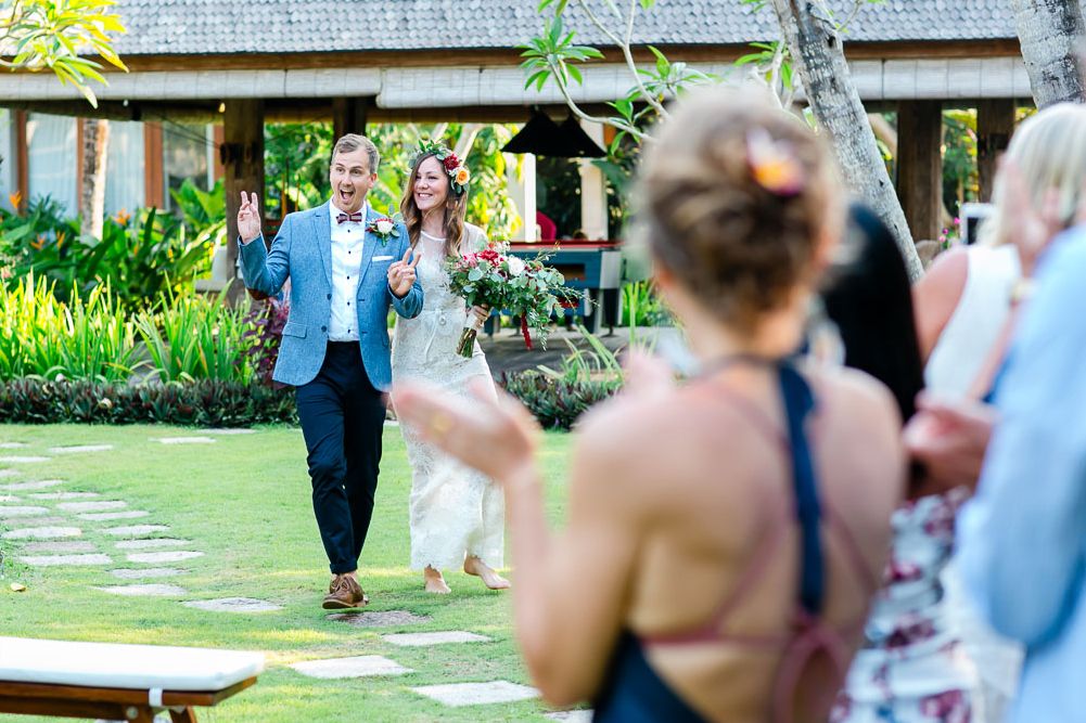 Wedding guests celebrate during an outdoor garden ceremony.