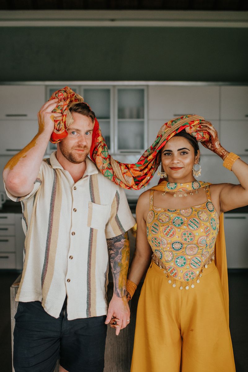 Playful couple poses for a series of photos showing affection and laughter in contrasting yellow and white attire.