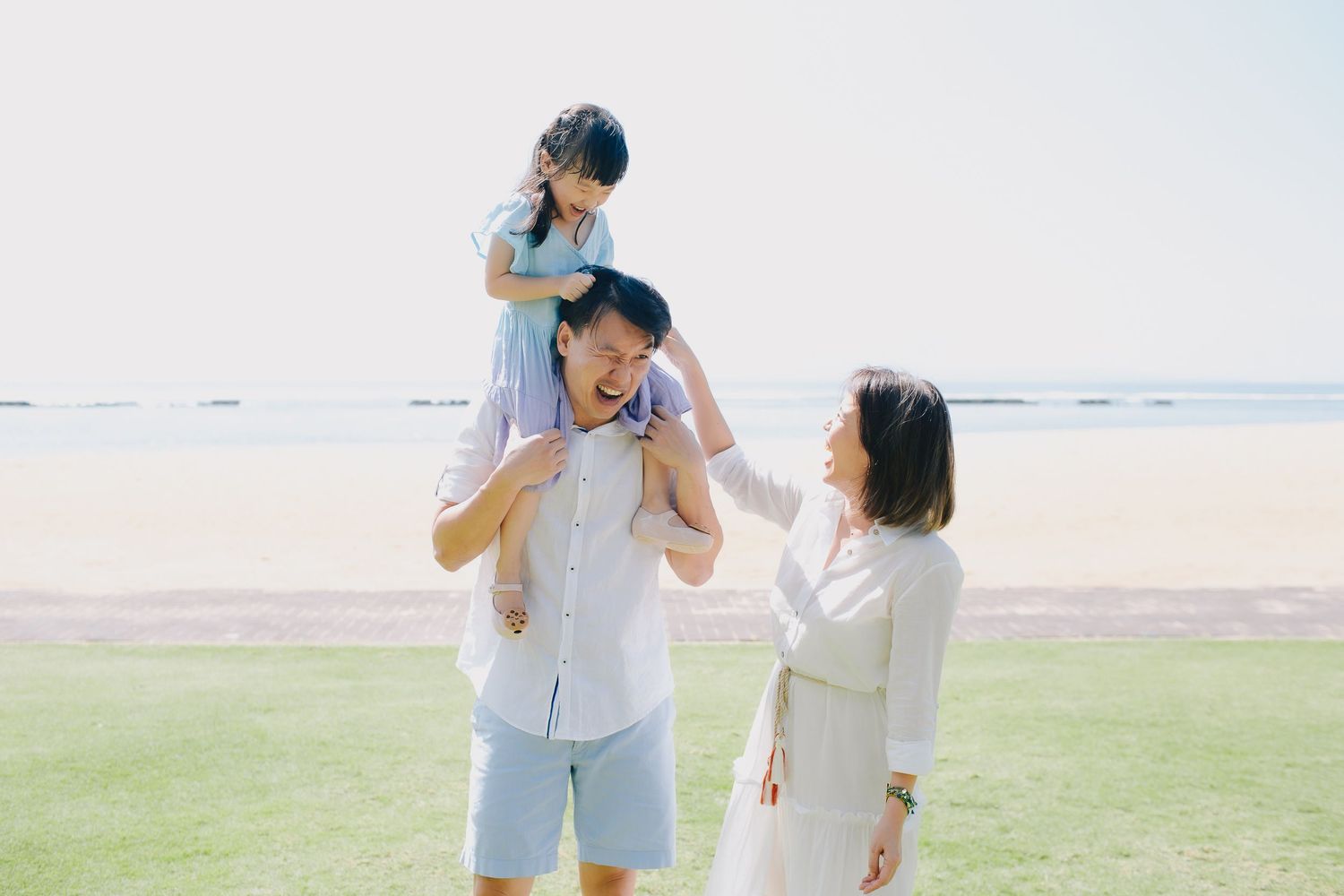 Joyful interactions on a bright sunny beach with ocean in background.